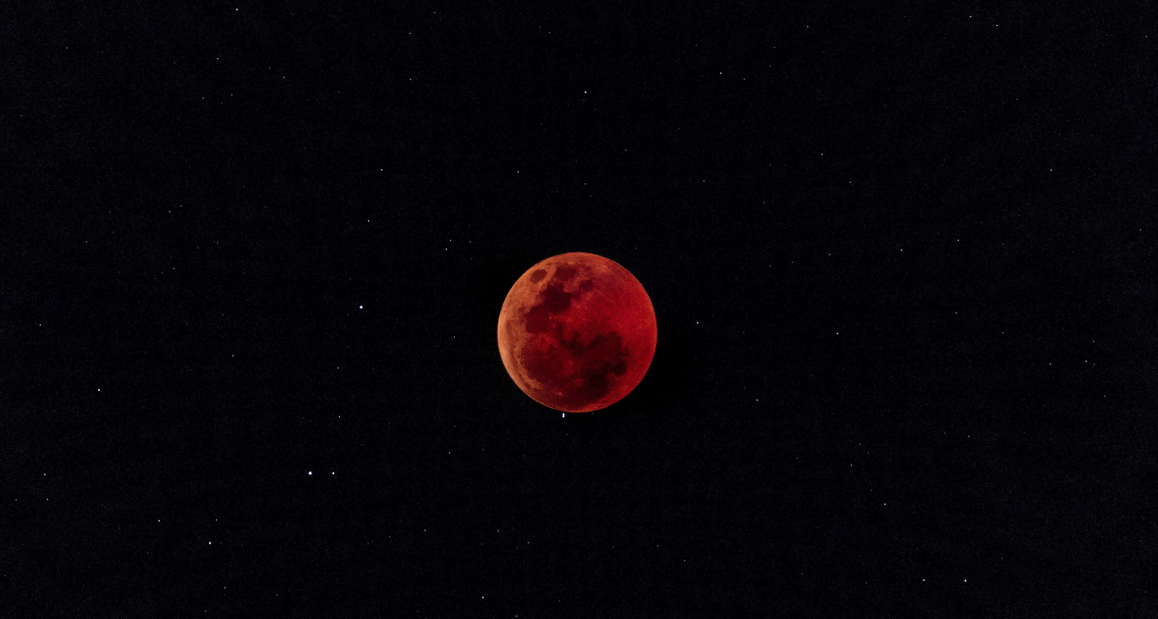 Red Moon 桌布 壁紙 — 血紅色的月亮在繁星點點的夜空中閃耀，呈現天體月食。