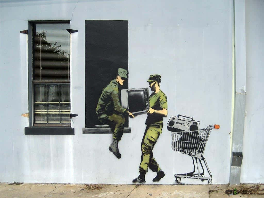 Banksy 桌布 壁紙 — 街頭藝術壁畫描繪兩名士兵，一名坐在窗邊拿著電視，另一名推著裝有音箱的購物車。