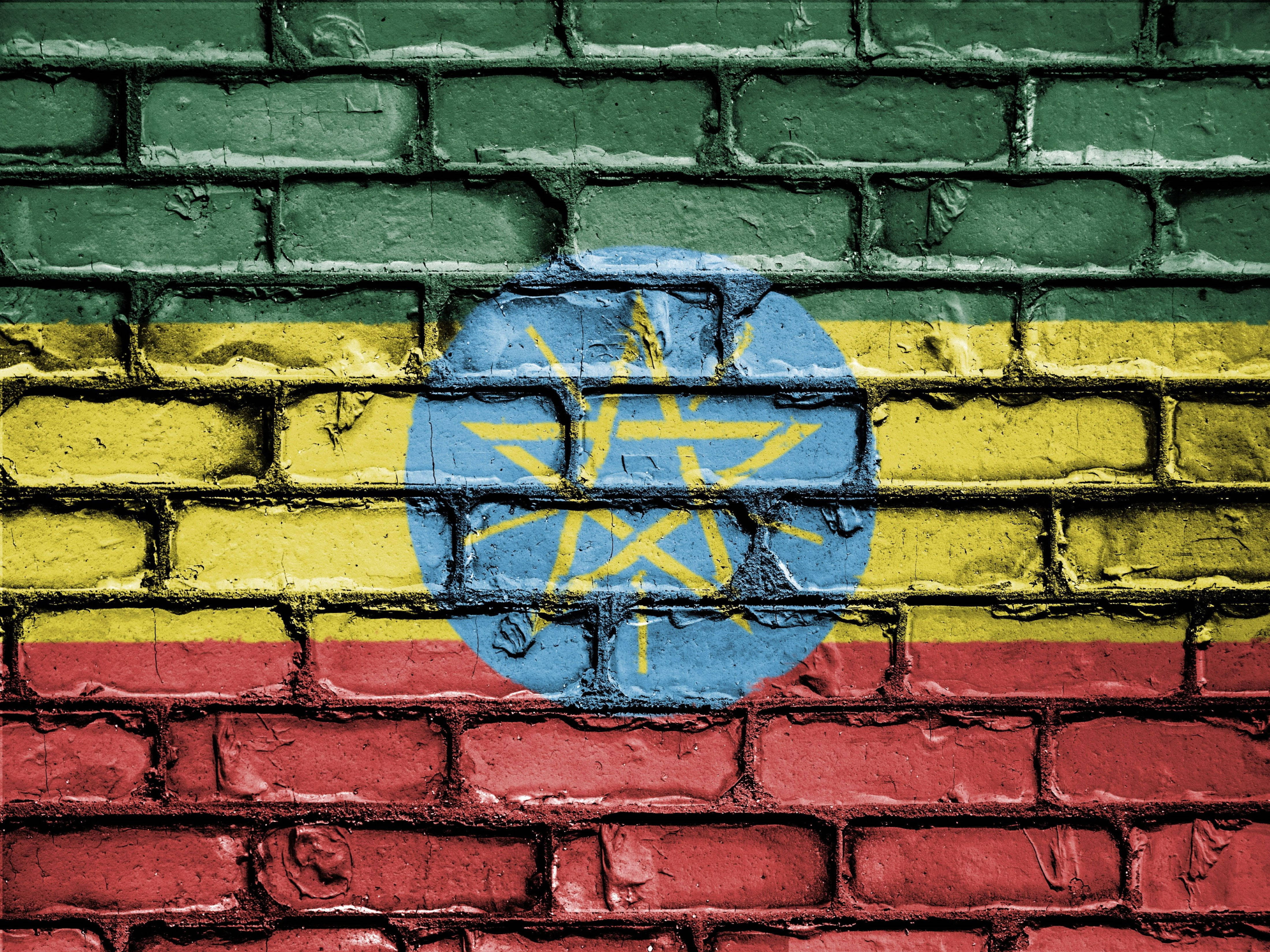 Ethiopia 桌布 壁紙 — 衣索比亞國旗繪在風化的綠色磚牆上，可見紋理和裂縫。