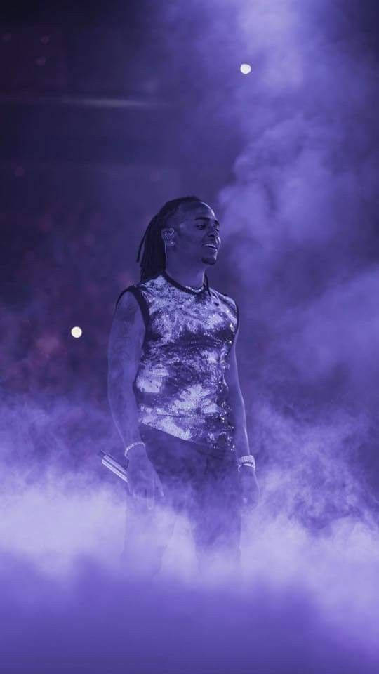 Ozuna 桌布 壁紙 — 表演者站在紫色霧氣中的舞台上，身後有發光的燈光。