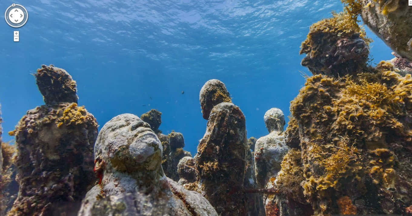 Underwater Scary Ocean 桌布 壁紙 — 被珊瑚和海藻覆蓋的水底雕像從清澈藍色海水下的海床升起。