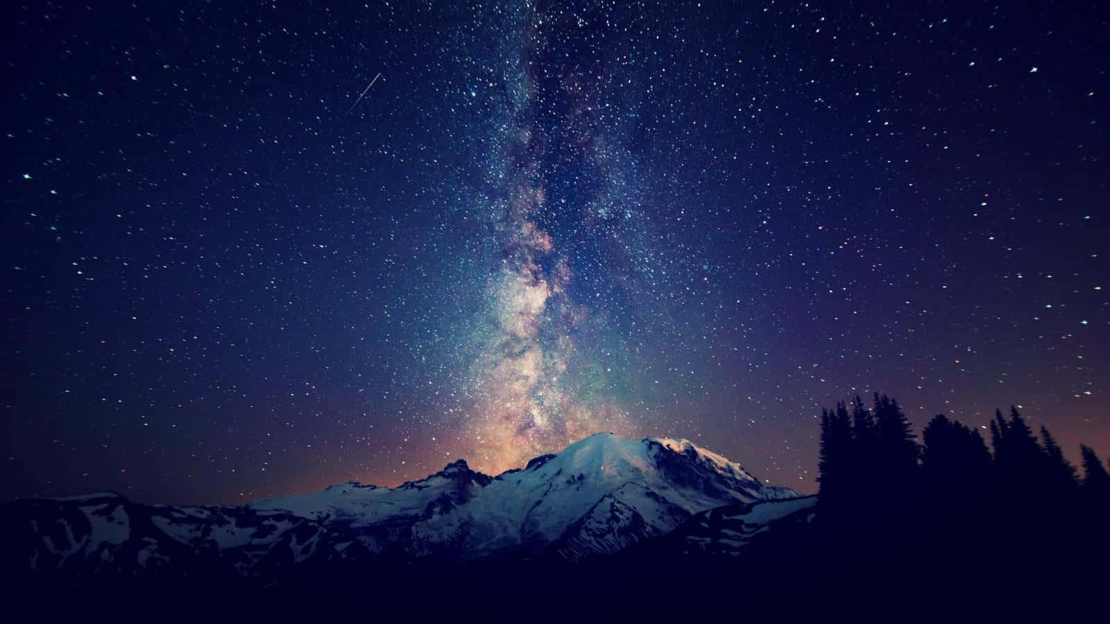 Stars 桌布 壁紙 — 被雪覆蓋的山脈在燦爛星空夜空下形成剪影，銀河在上方閃耀。