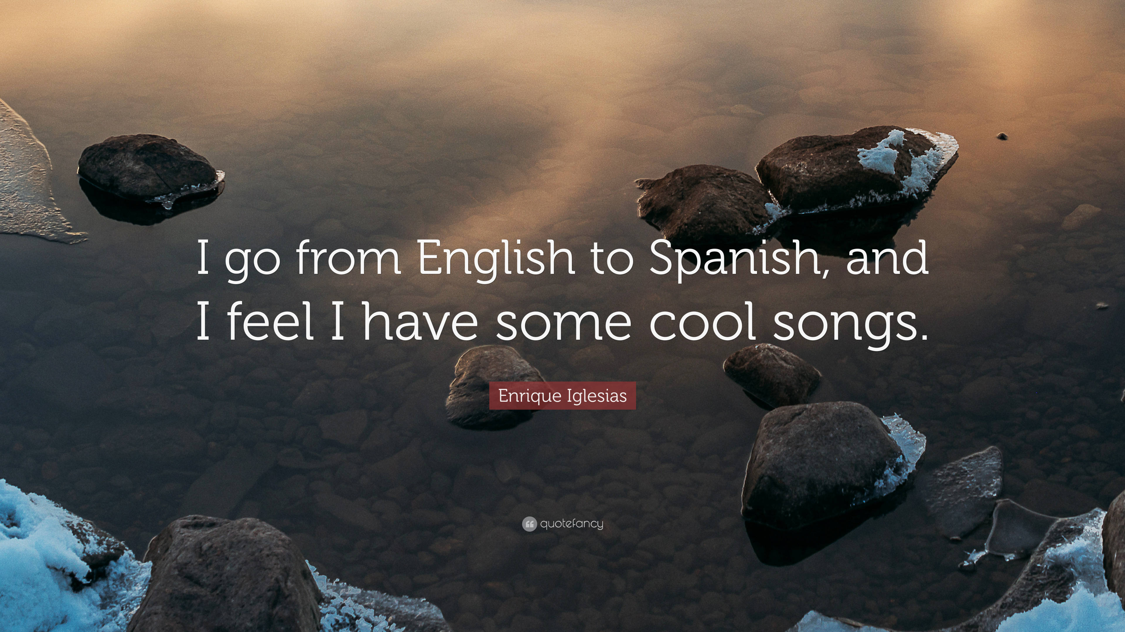 Quote 桌布 壁紙 — 被雪覆蓋的岩石靜臥在平靜的水中，反射著金色的日出光芒，並疊加了一句名言。