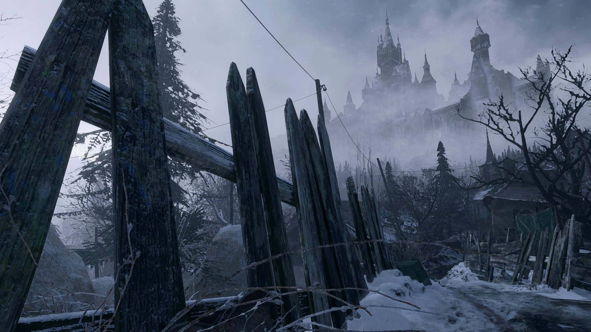 Resident Evil Village 桌布 壁紙 — 被雪覆蓋的木柵欄框住一座從冬季冰凍森林中升起的霧氣瀰漫的哥德式城堡。