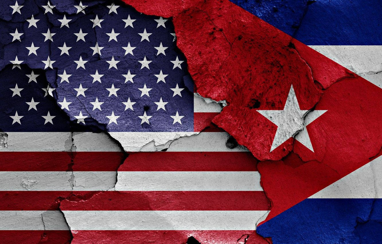 Cuban 桌布 壁紙 — 裂縫牆藝術，展示撕裂的美國和古巴國旗並排，帶有紋理油漆和粗糙邊緣。