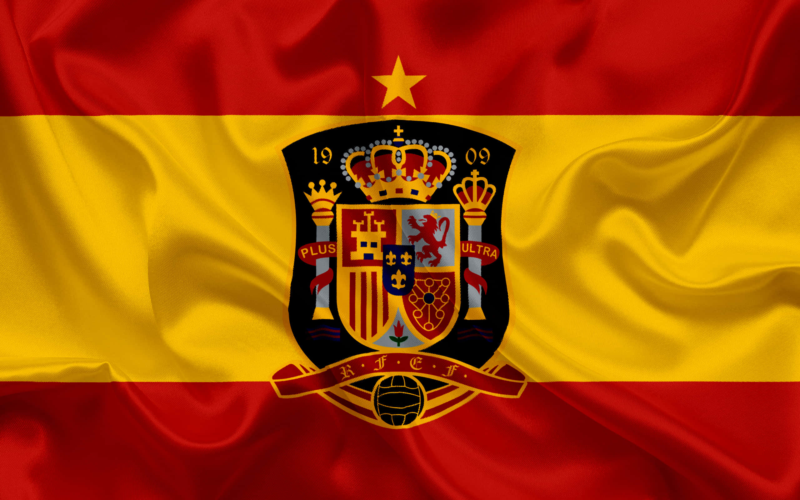 Spanish 桌布 壁紙 — 西班牙國家足球隊旗幟飄揚，帶有豐富的紅色和金色條紋，以及一個包含皇冠和足球的詳細徽章。