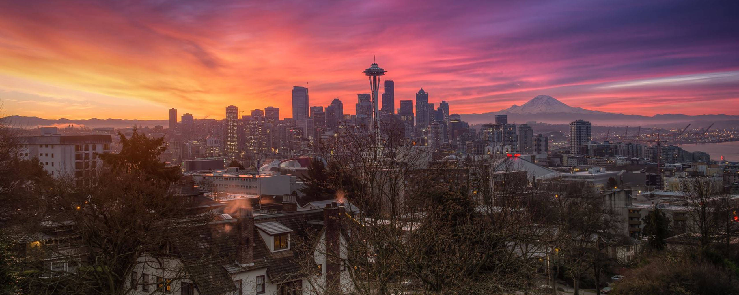 Seattle 桌布 壁紙 — 西雅圖天際線在日落時分，太空針塔和雷尼爾山在火紅的粉紅色和橙色雲彩下閃耀。