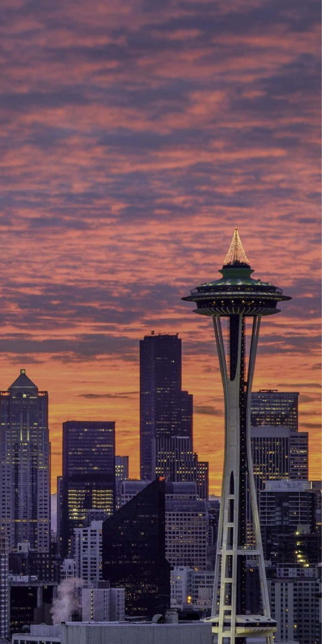 Pixel 3 Seattle 桌布 壁紙 — 西雅圖天際線在日落時分，太空針塔在火紅橙色和紫色雲彩中閃耀。
