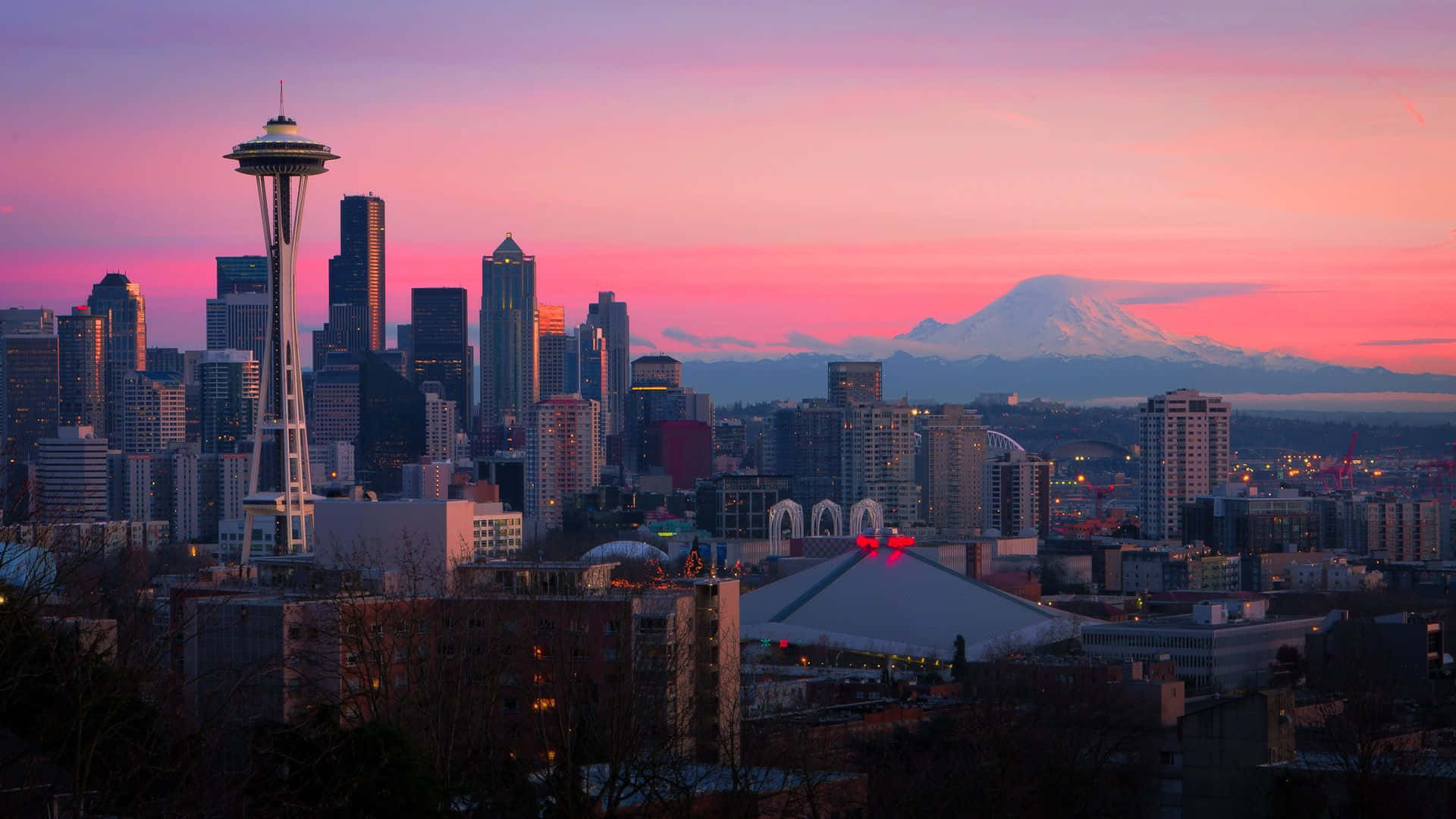 Washington 桌布 壁紙 — 西雅圖天際線在日落時分，太空針塔和積雪的雷尼爾山在粉紅色和紫色色調中閃耀。