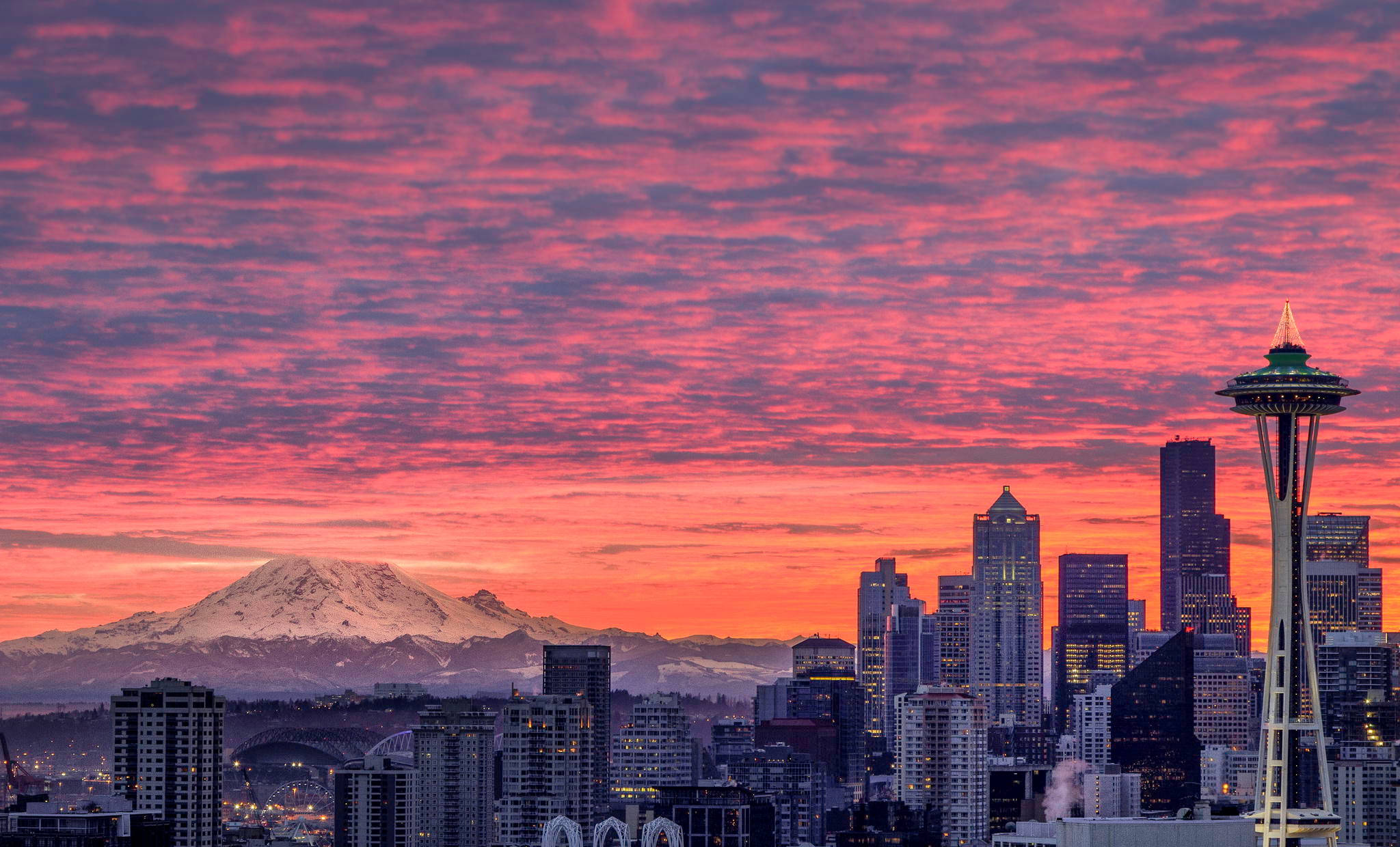 Seattle 桌布 壁紙 — 西雅圖天際線在日落時分，太空針塔和積雪的雷尼爾山在火紅的粉紅色和橙色雲層下。