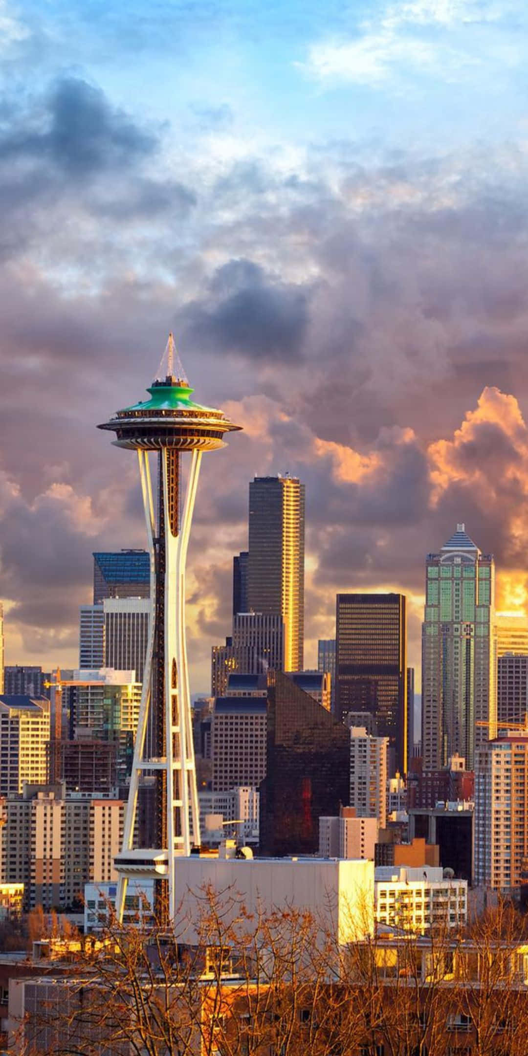 Pixel 3 Seattle 桌布 壁紙 — 西雅圖天際線在日落時分，太空針塔在戲劇性的橙色和紫色雲彩中閃耀。