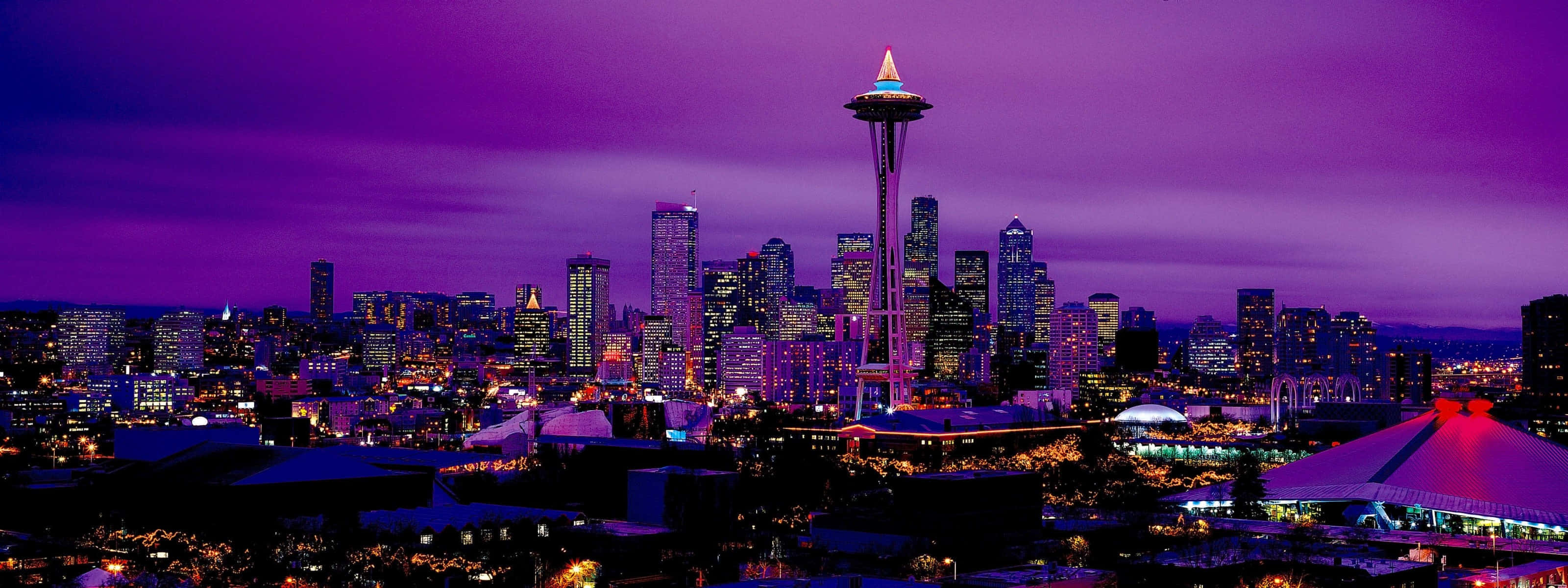 City Night 桌布 壁紙 — 西雅圖天際線在黃昏時分，太空針塔在充滿活力的洋紅色天空下發出紫色光芒。