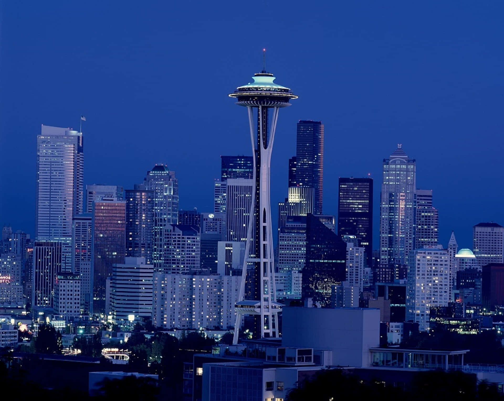 Best Seattle 桌布 壁紙 — 西雅圖天際線在黃昏時分，太空針塔在深藍色天空中閃耀。