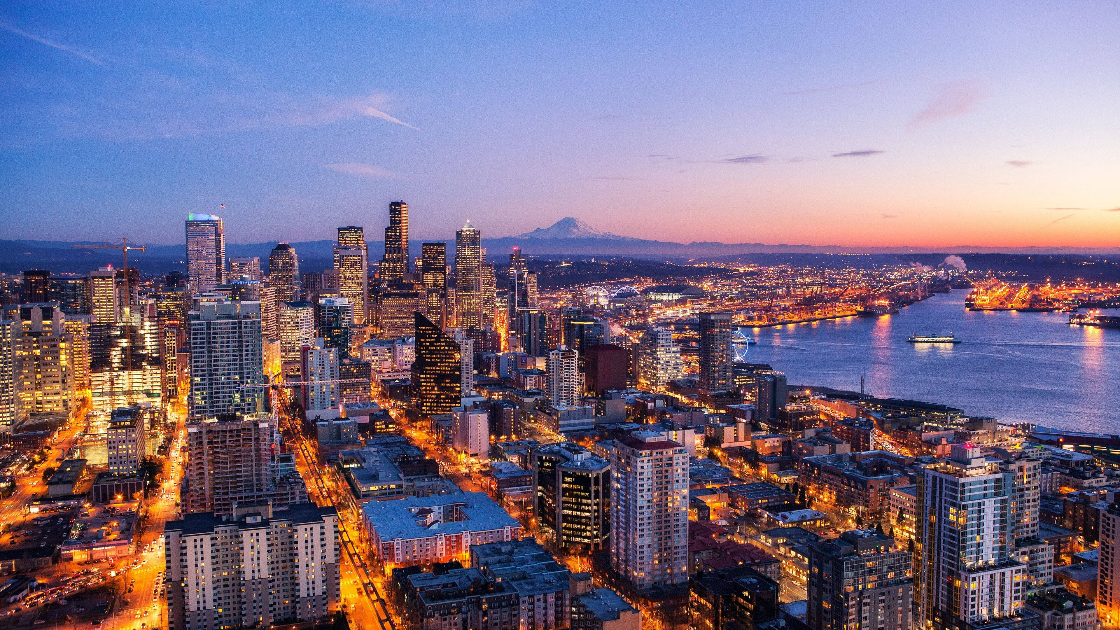 Portland 桌布 壁紙 — 西雅圖天際線在黃昏時的鳥瞰圖，城市燈光閃爍，遠處可見雷尼爾山。