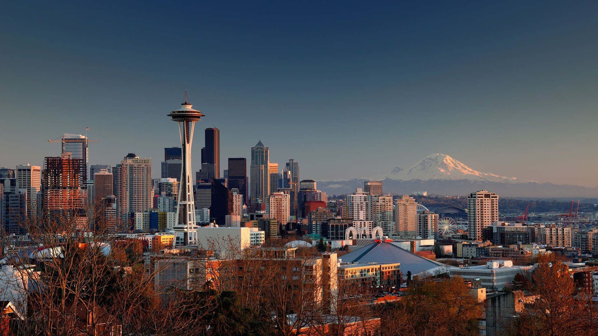 Seattle 桌布 壁紙 — 西雅圖天際線在黃金時刻，遠方有太空針塔和積雪的雷尼爾山。