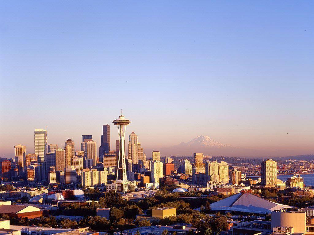Space Needle 桌布 壁紙 — 西雅圖天際線在黃金時刻，遠處有太空針塔和積雪的雷尼爾山。