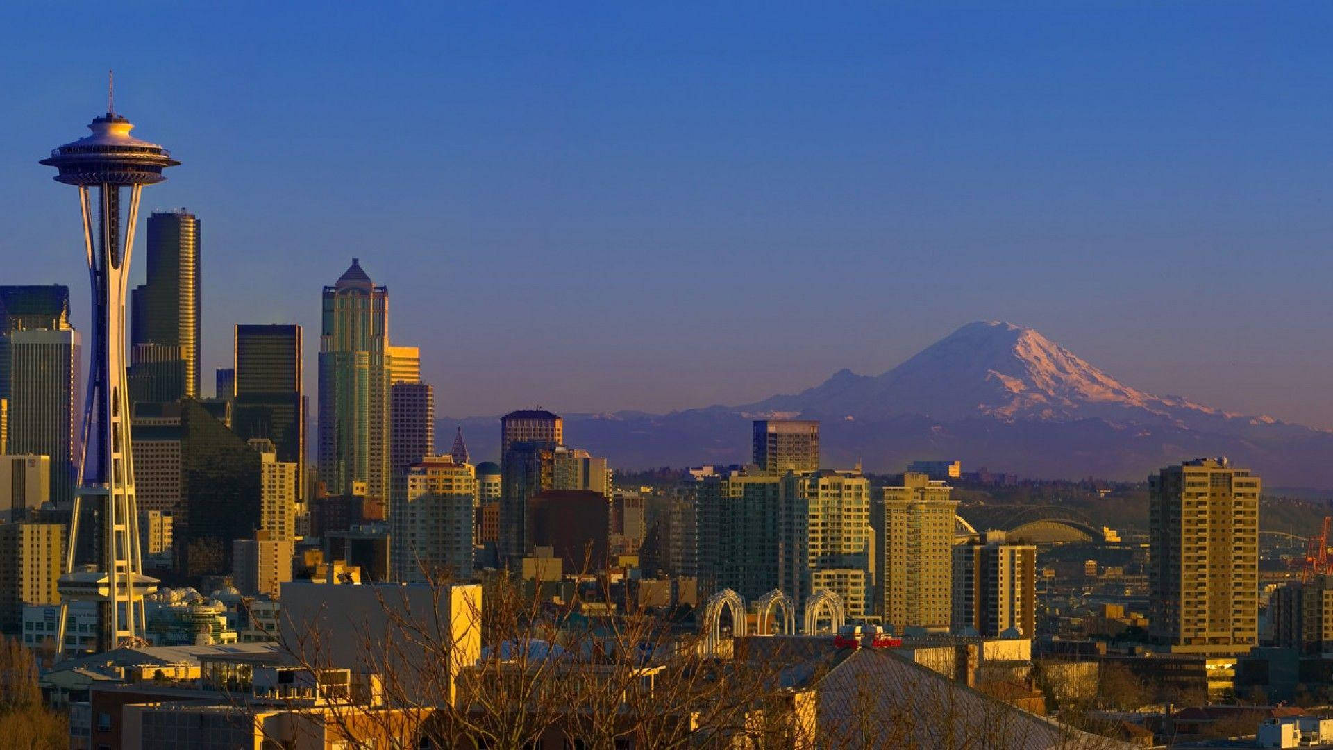 Seattle 桌布 壁紙 — 西雅圖天際線在黃金時刻，遠處有太空針塔和積雪的雷尼爾山。