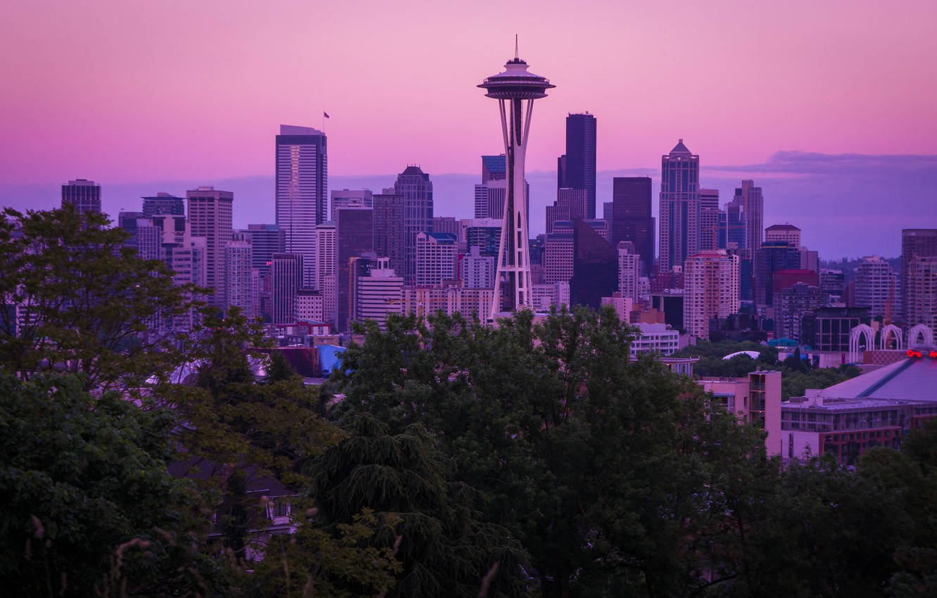 Seattle Skyline 桌布 壁紙 — 西雅圖天際線沐浴在暮色紫調中，太空針塔聳立在茂密綠樹之上。