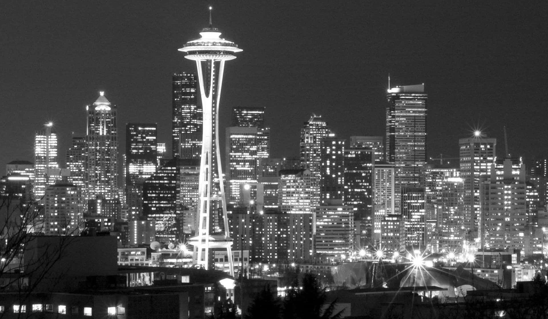 Seattle Black And White 桌布 壁紙 — 西雅圖天際線的醒目黑白夜景，以發光的太空針塔和閃爍的摩天大樓為主導。