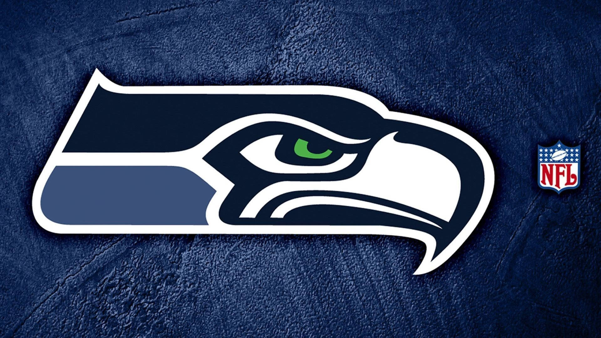 NFL Teams 桌布 壁紙 — 西雅圖海鷹隊標誌，在帶有紋理的深藍色背景上，有綠色眼睛和NFL盾牌。