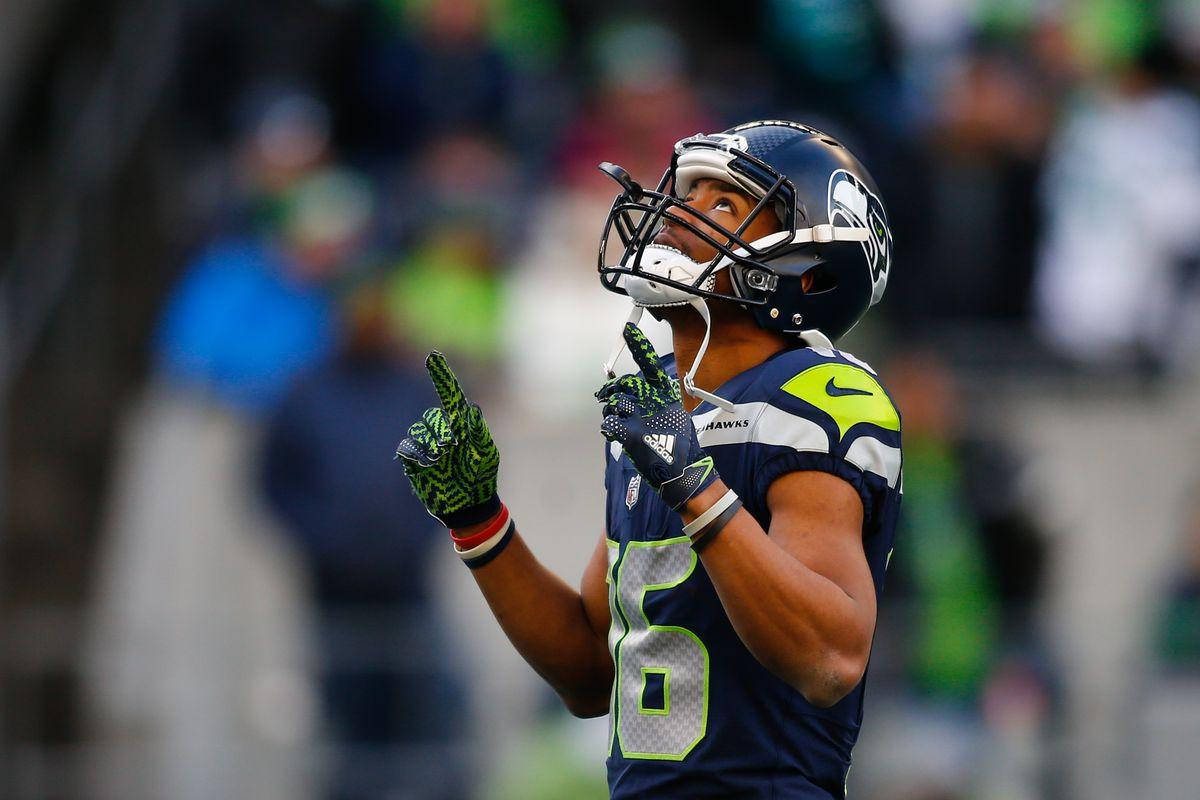 Seattle Seahawks 桌布 壁紙 — 西雅圖海鷹隊球員身穿藍綠球衣，在日間比賽中舉起手指慶祝。