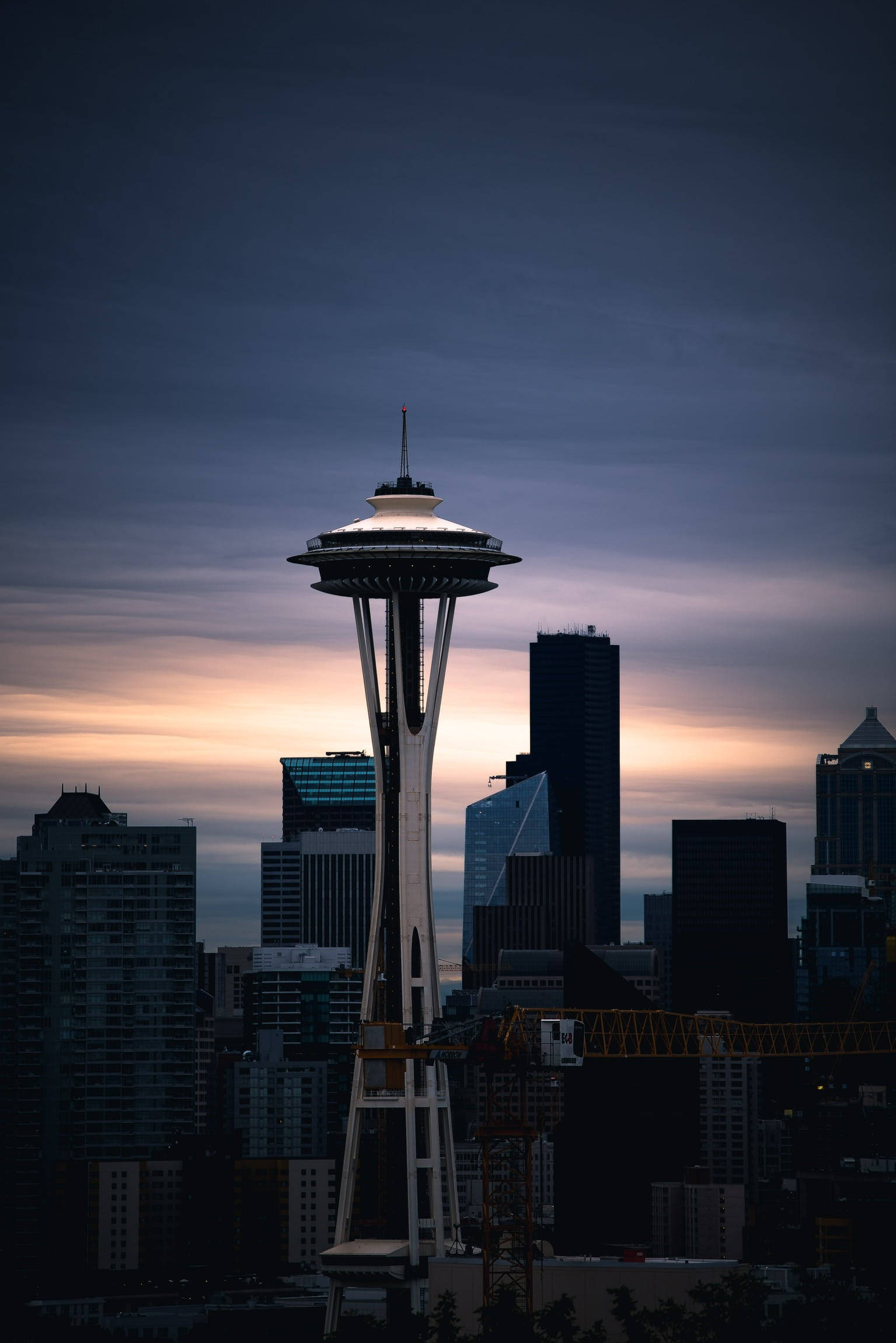 Space Needle 桌布 壁紙 — 西雅圖的太空針塔在暮色天空中閃耀，城市天際線上方呈現柔和的橙色和紫色色調。