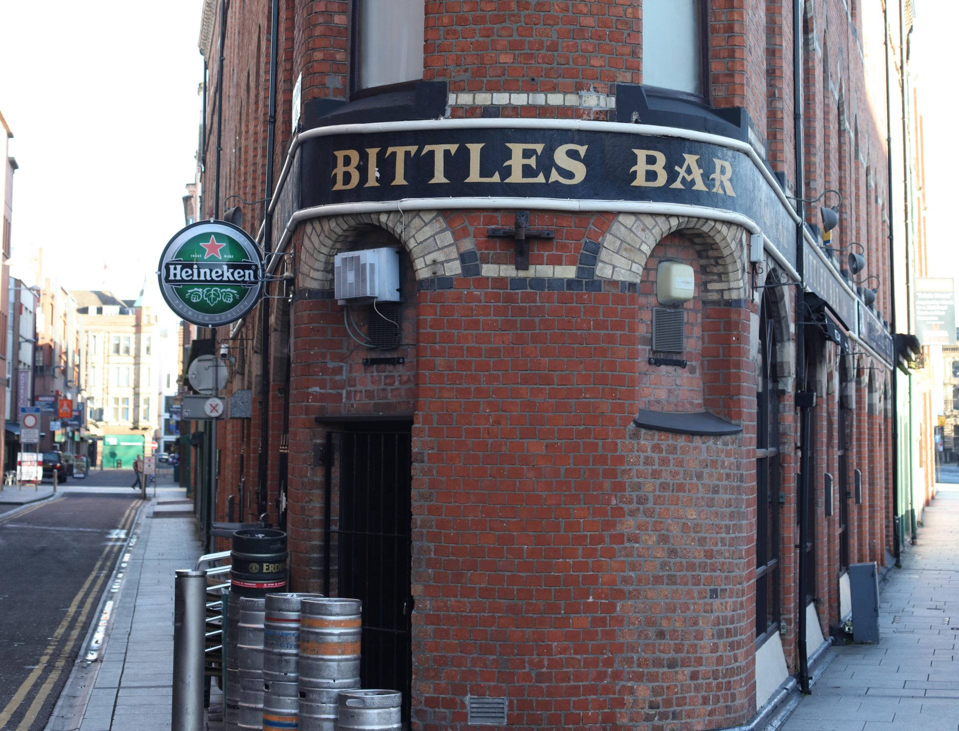 Brick 桌布 壁紙 — 角落磚砌酒吧，帶有「Bittles Bar」招牌和喜力標誌，在明亮日光下。