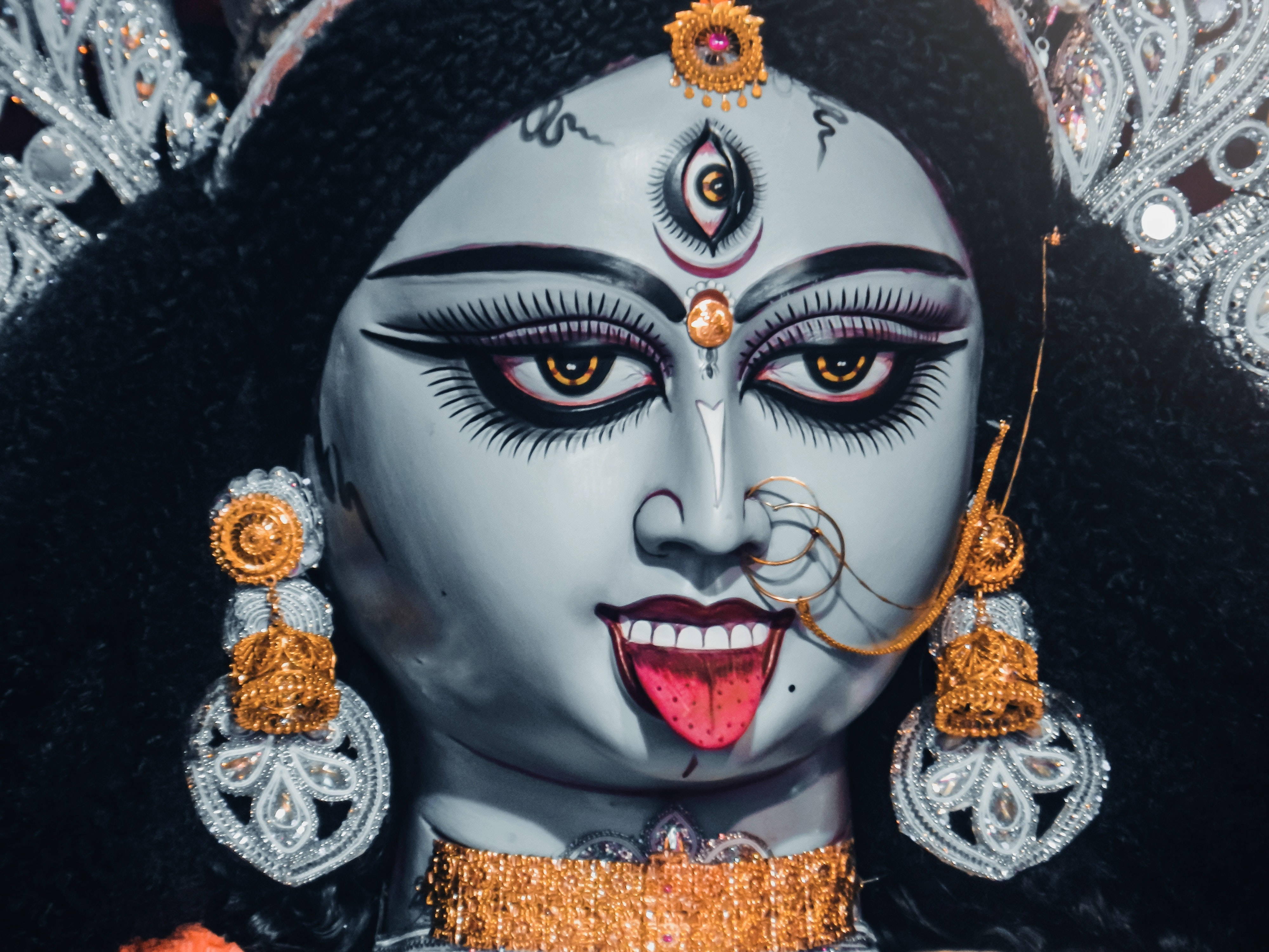 Goddess 桌布 壁紙 — 詳細的杜爾迦神像特寫，帶有銀飾、金色點綴和額頭上的第三隻眼。