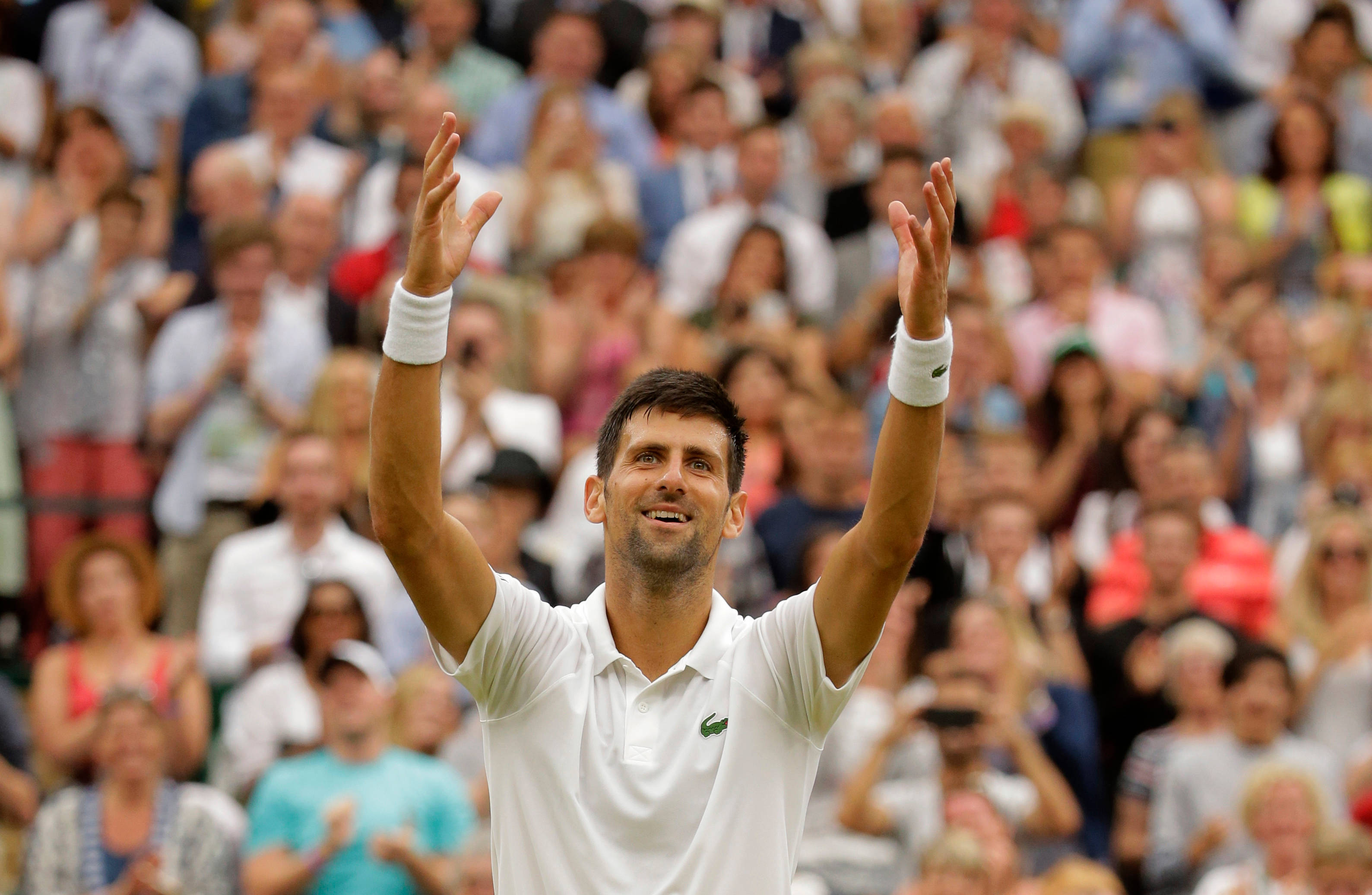 Novak 桌布 壁紙 — 諾瓦克·喬科維奇在網球比賽中高舉雙臂勝利微笑，觀眾鼓掌。