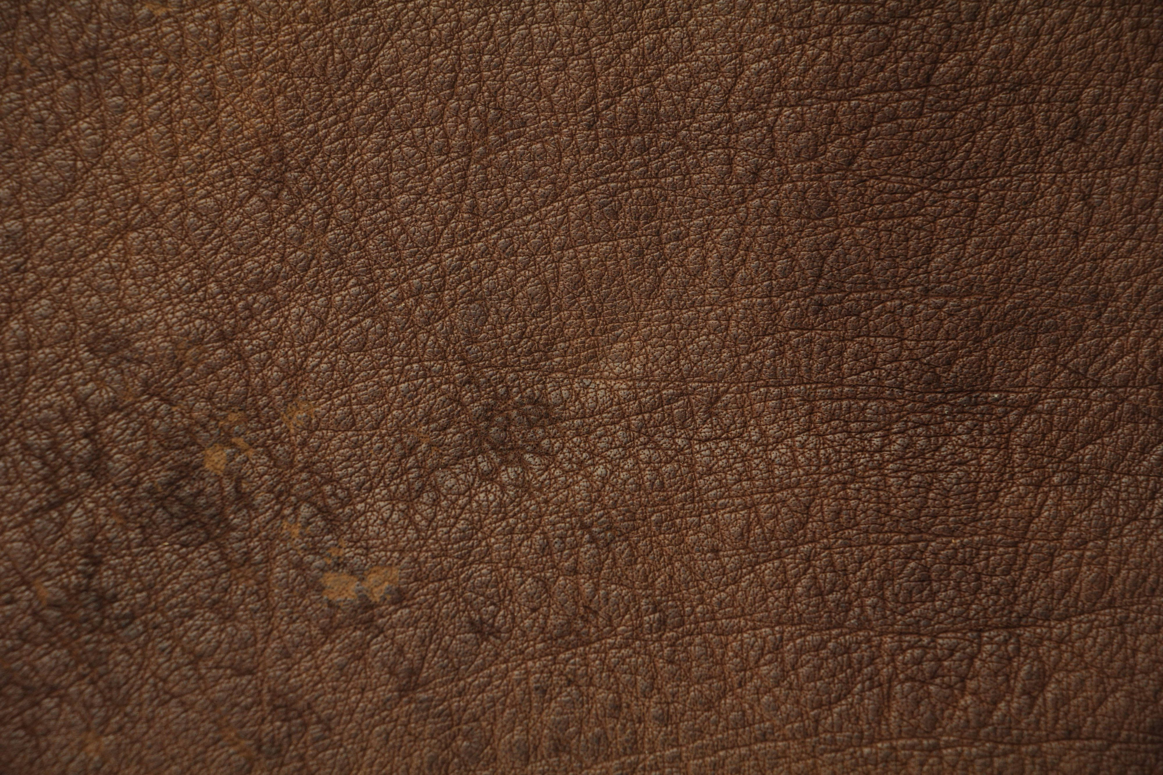 texture 桌布 壁紙 — 豐富棕色皮革的特寫，帶有自然皺紋和細微污漬，展現真實質感。