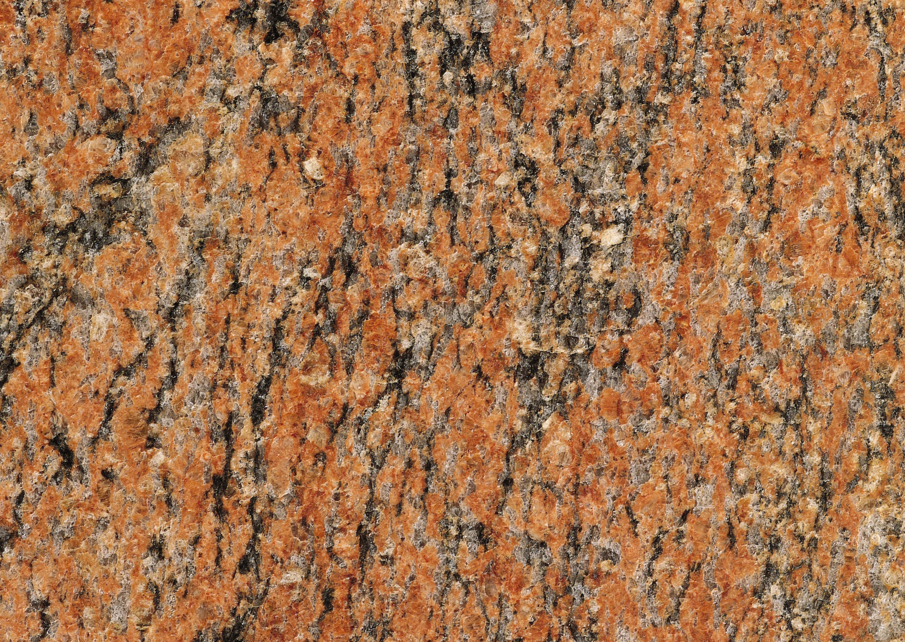 Granite 桌布 壁紙 — 豐富橙色花崗岩的特寫，黑色和灰色礦脈旋轉形成大膽的自然圖案。