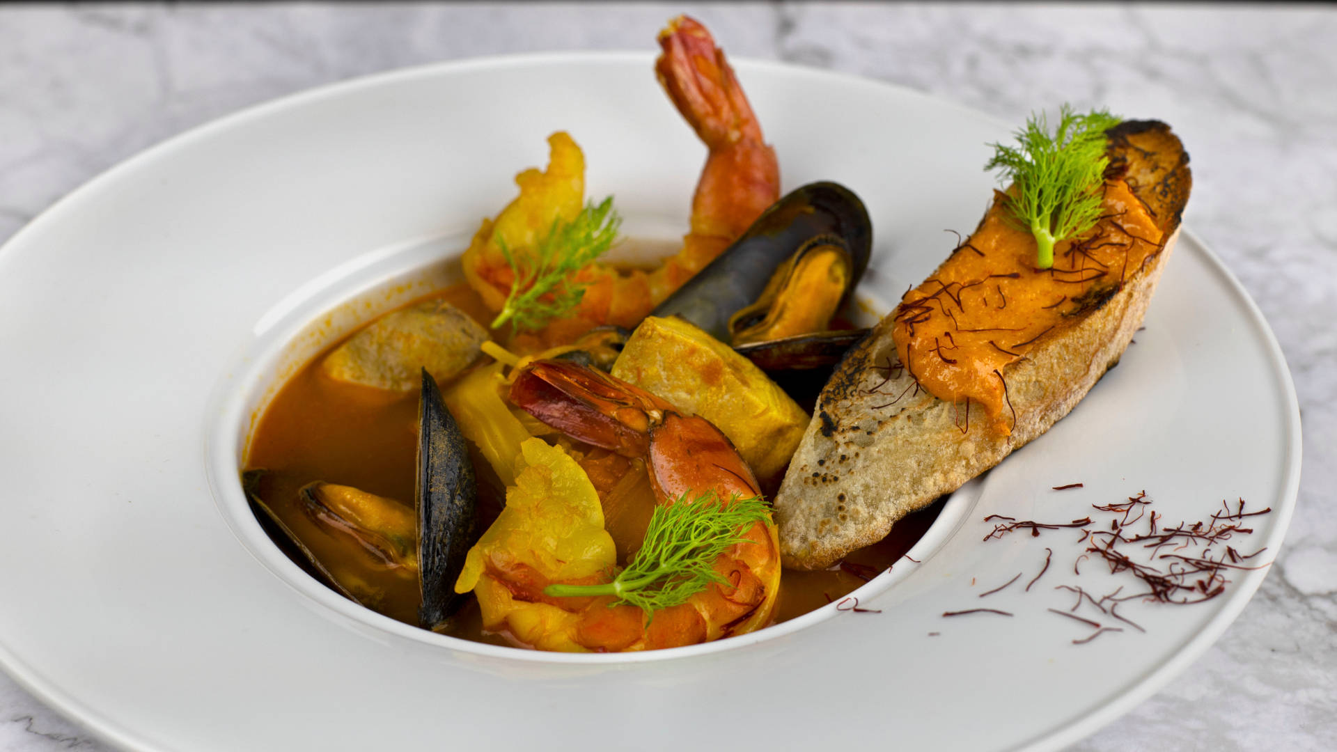 Food Photography 桌布 壁紙 — 豐富的海鮮燉菜，配有青口、蝦和茴香裝飾，搭配烤麵包放在白色盤子上。