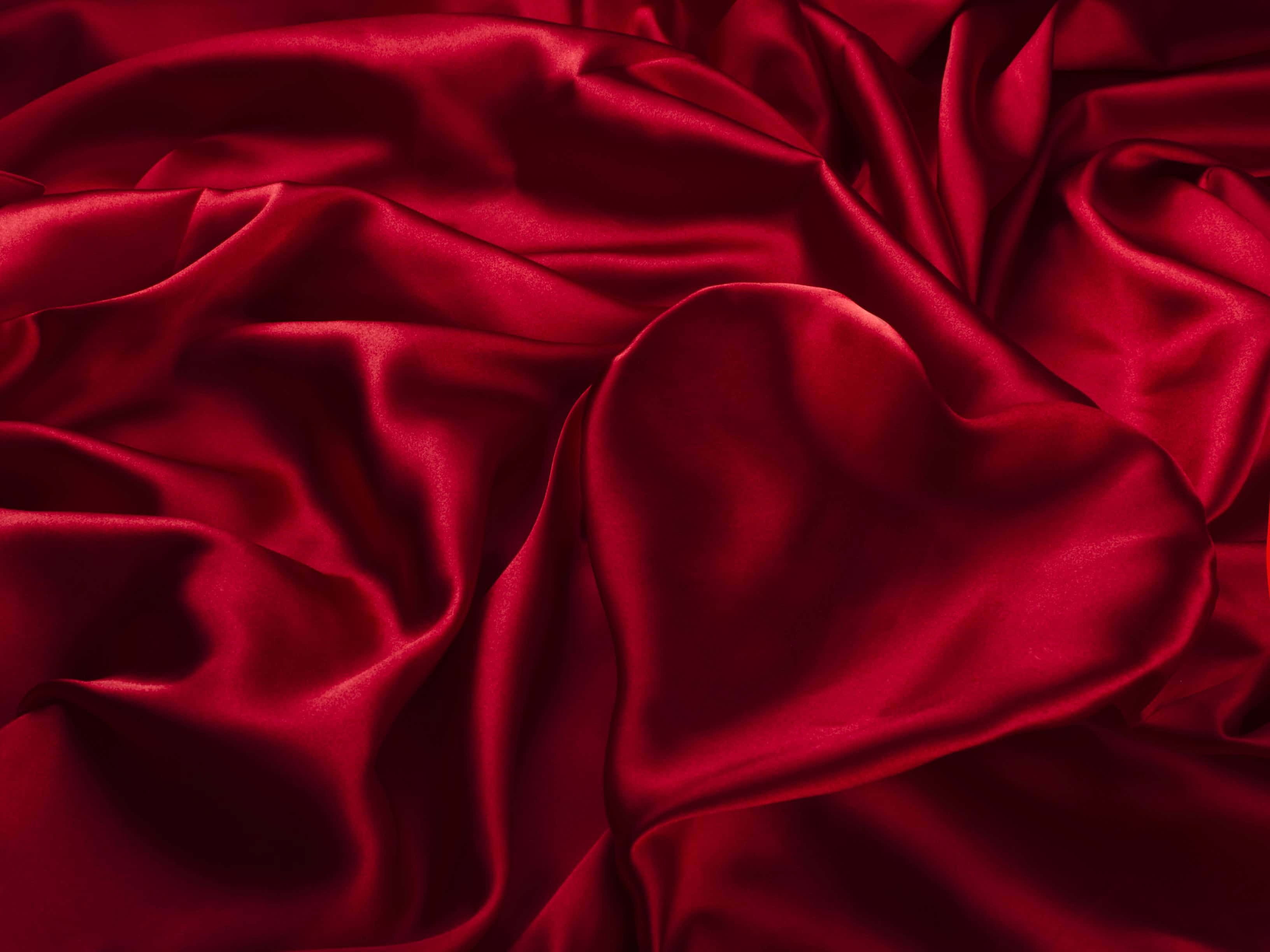 Silk 桌布 壁紙 — 豐富的深紅色緞面布料以柔軟起伏的波浪摺疊，捕捉光線，呈現光澤亮點和深邃陰影。