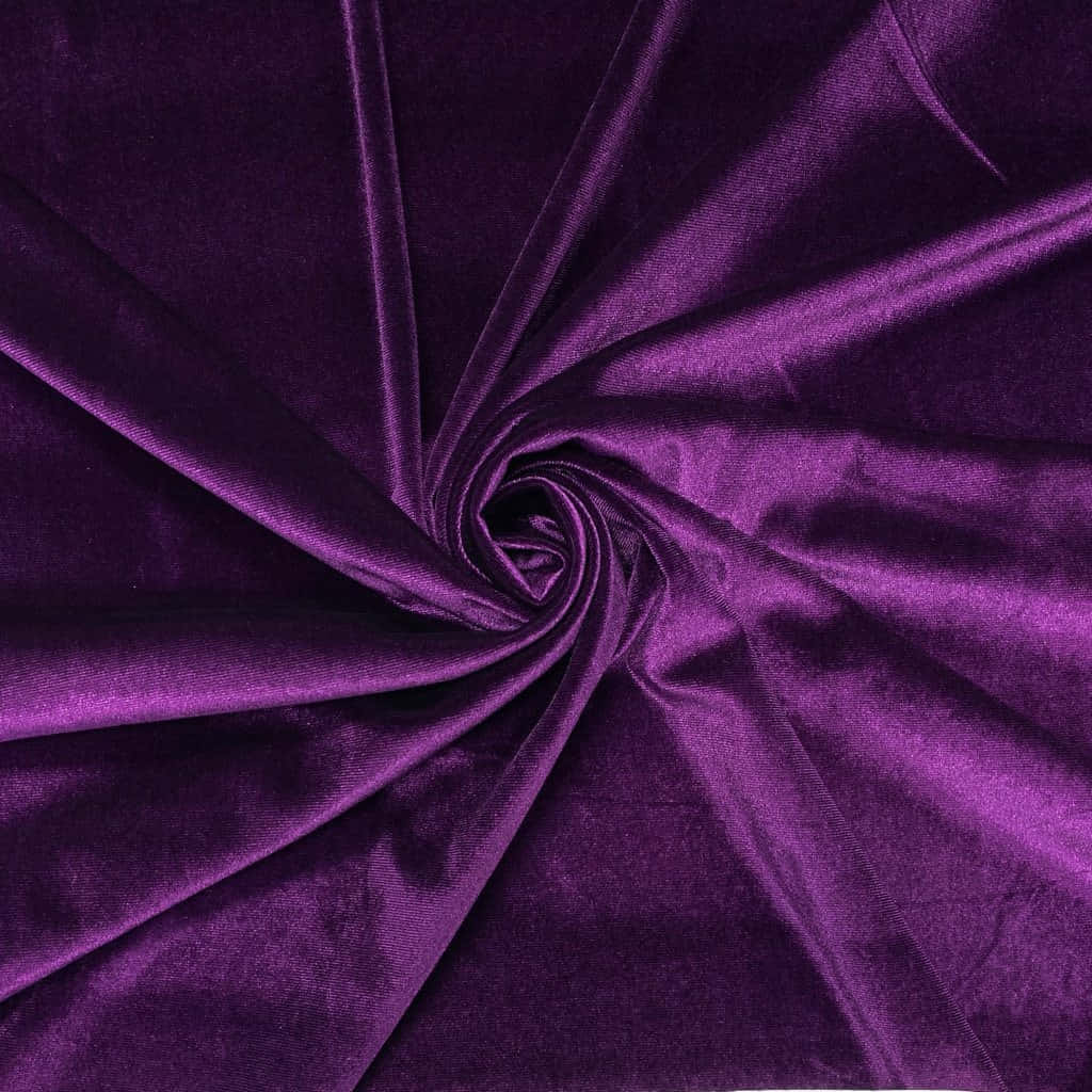 Purple Velvet 桌布 壁紙 — 豐富的紫色天鵝絨布料旋轉成緊密的漩渦，在均勻光線下展現深摺和柔和光澤。