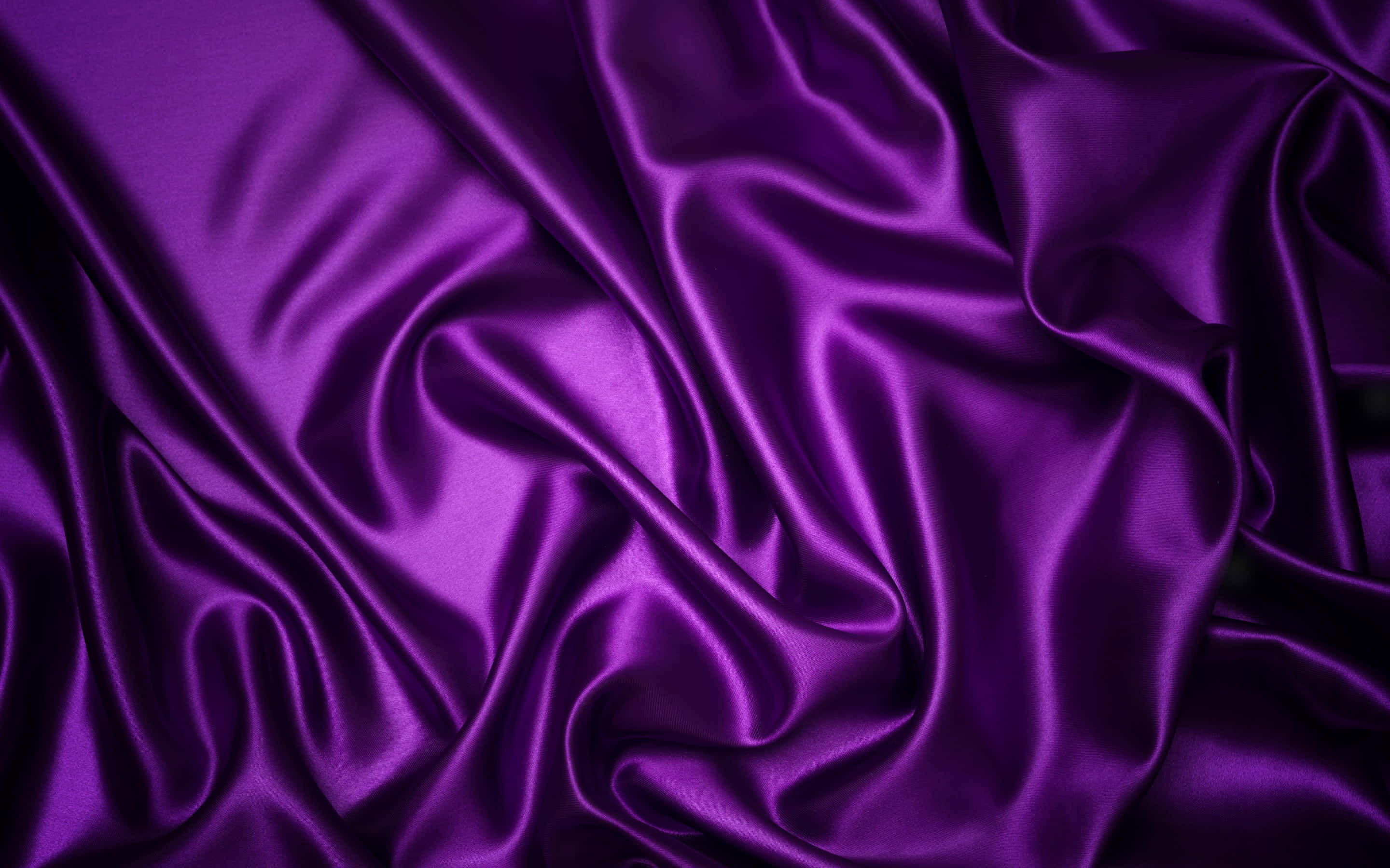 Purple Fabrics 桌布 壁紙 — 豐富的紫色緞面布料，帶有深層褶皺和光澤亮點，營造出奢華華麗的質感。