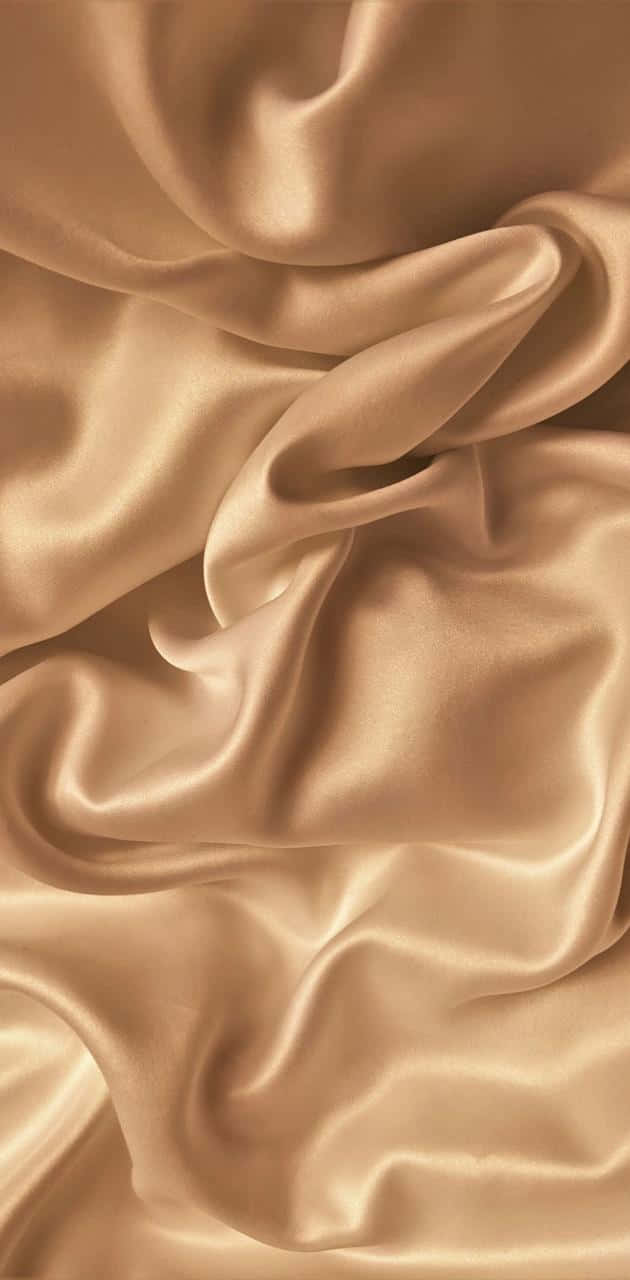 Gold Silk 桌布 壁紙 — 豐富的金色絲綢布料在柔和的波浪中流動，捕捉溫暖光線，帶有細微光澤。