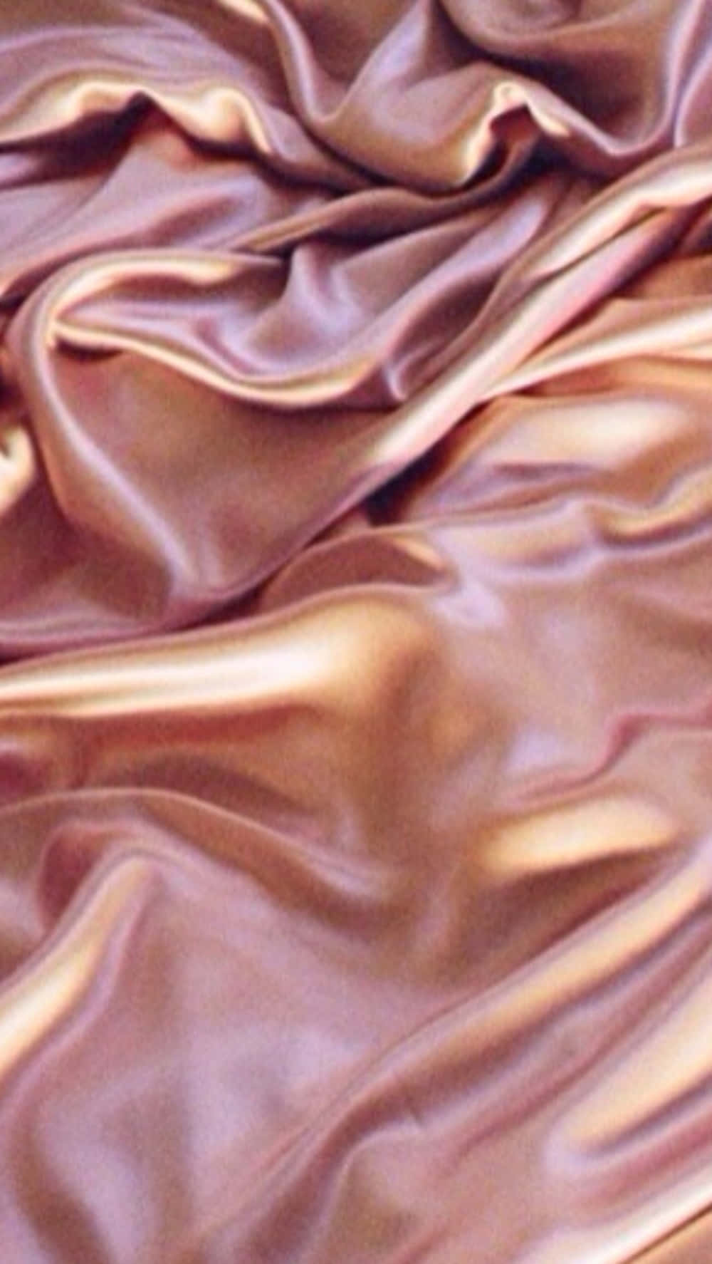 Aesthetic Rose Gold 桌布 壁紙 — 豐富的青銅色緞面布料，帶有光澤的褶皺，在奢華的特寫中捕捉柔和光線。