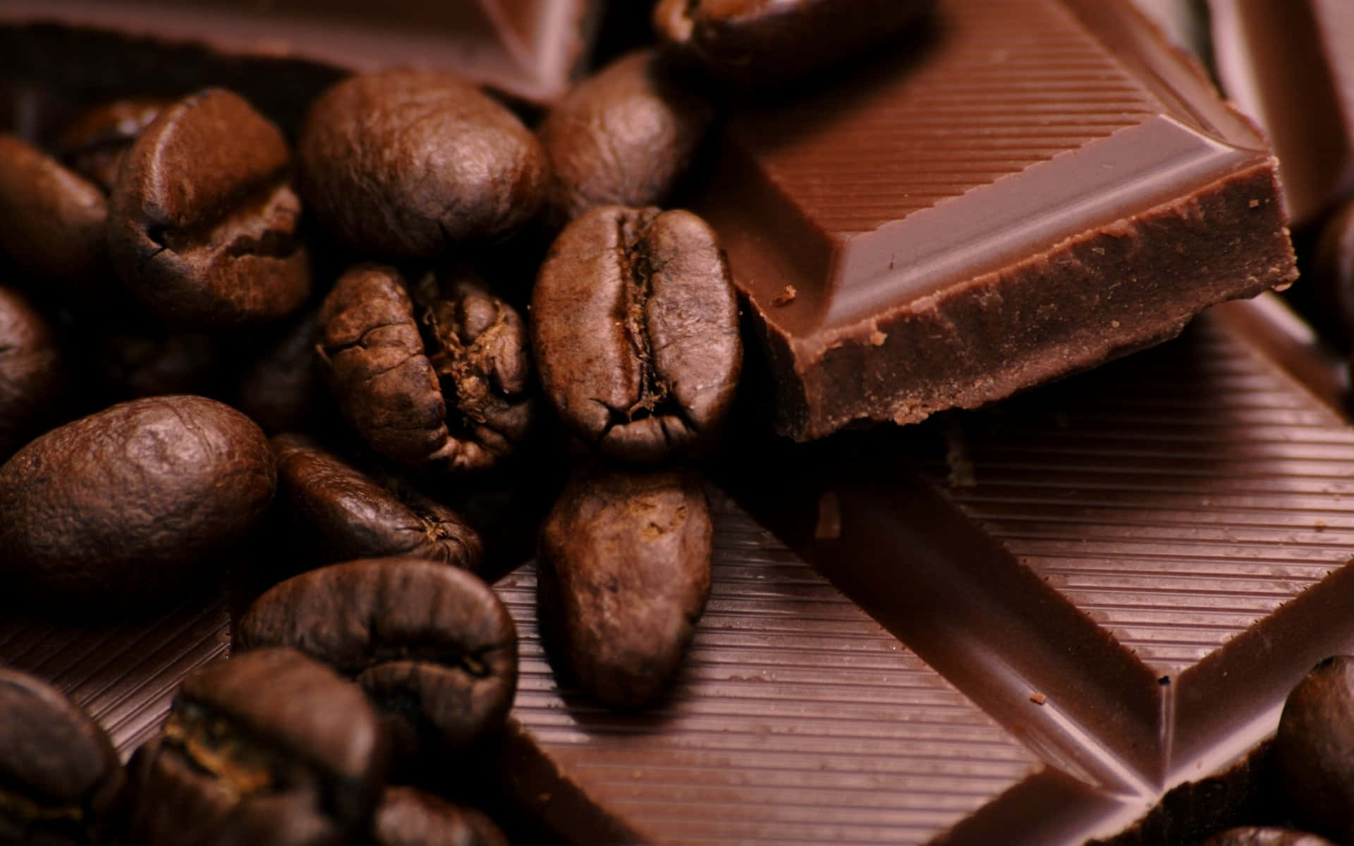 Brown Chocolate 桌布 壁紙 — 豐富的黑巧克力條和烘焙咖啡豆以頹廢的特寫方式排列，帶有深棕色調和紋理表面。