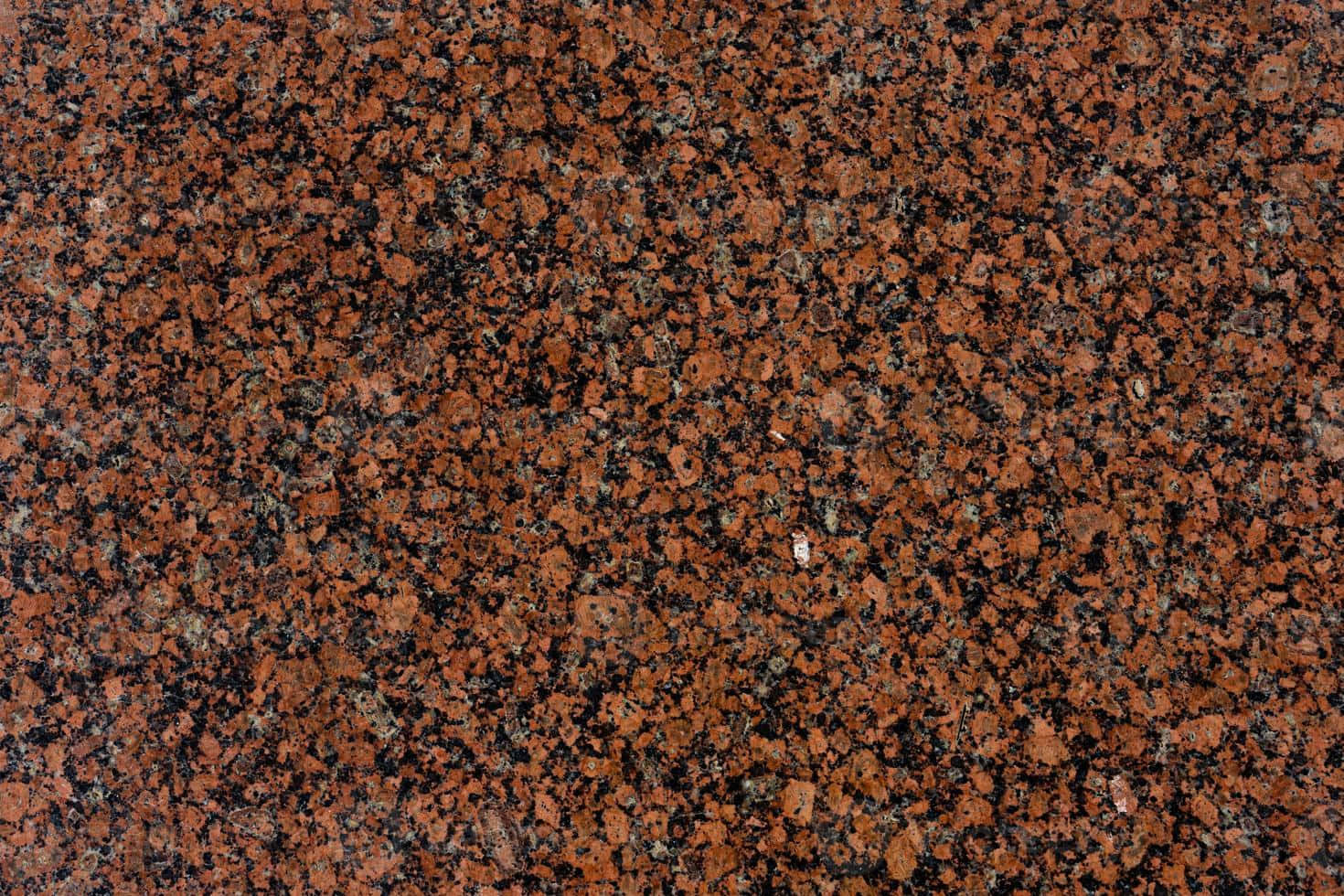 Granite 桌布 壁紙 — 豐富紅色和黑色斑點花崗岩表面的特寫，帶有天然礦物質紋理。