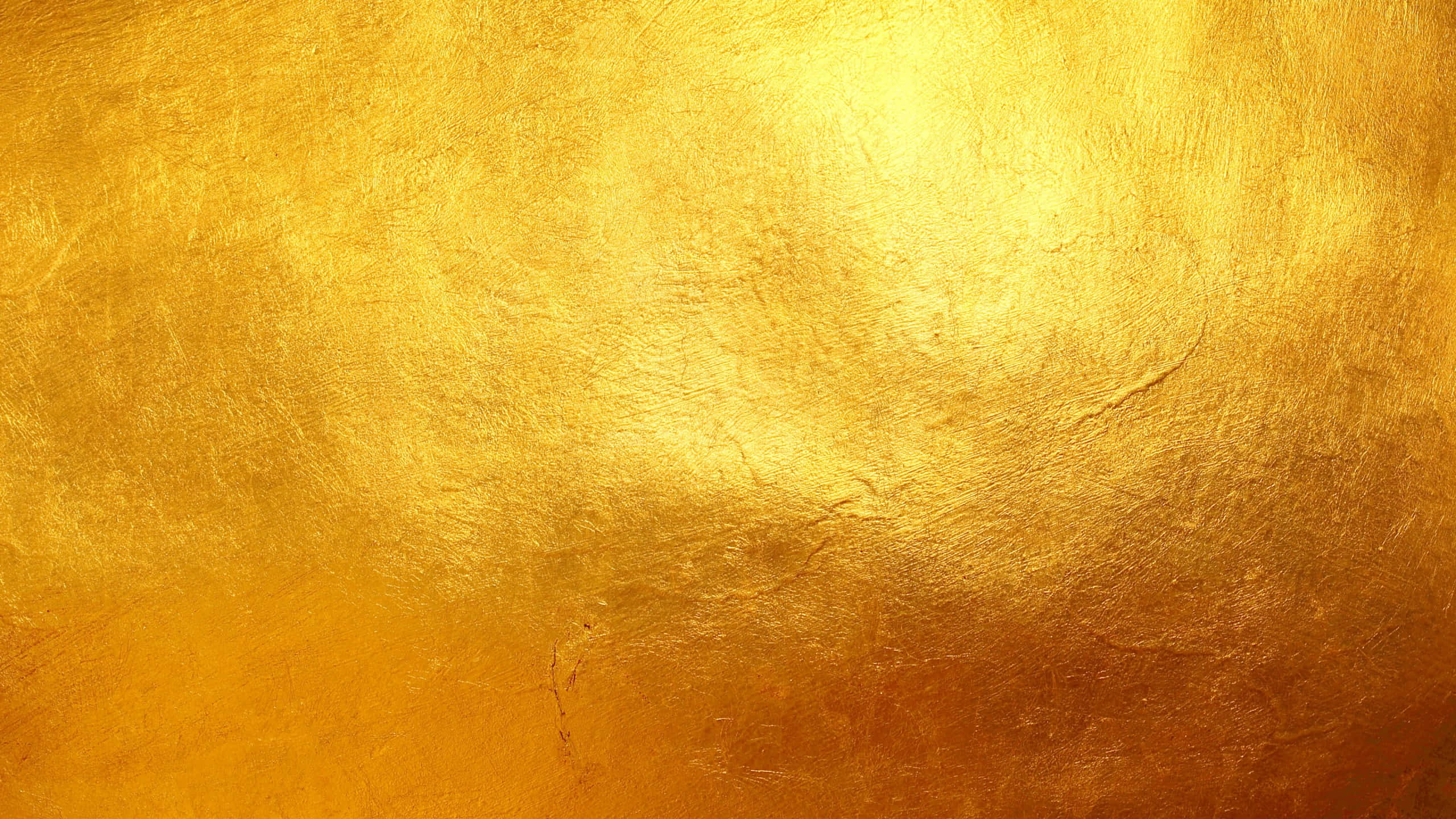 Yellow Grunge 桌布 壁紙 — 豐富紋理的金色表面，色調和光線有細微變化，光線在其不均勻的金屬飾面上反射。
