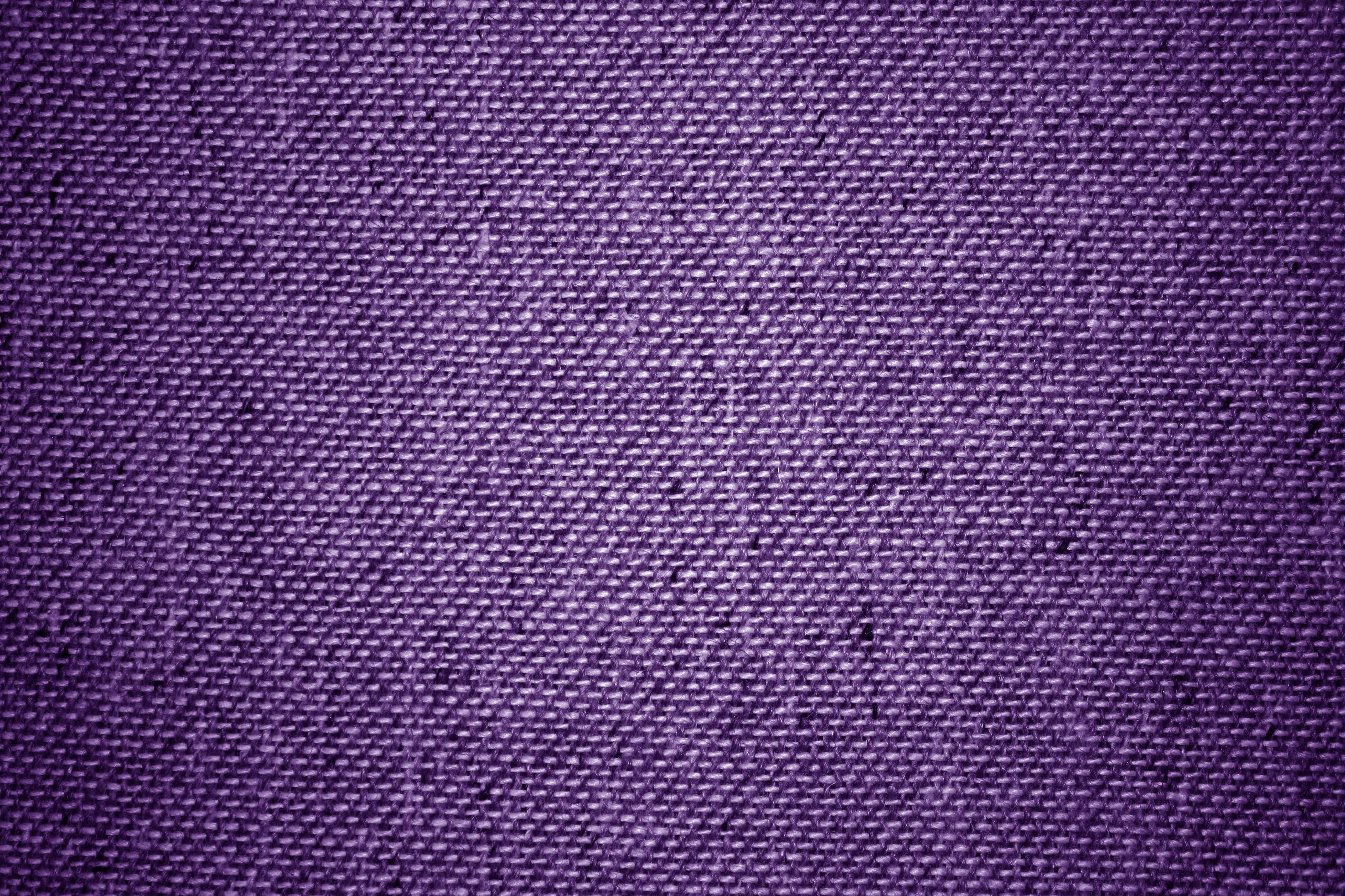 Purple Fabrics 桌布 壁紙 — 豐富紫色編織布料的特寫，具有可見紋理和微妙的色調變化。