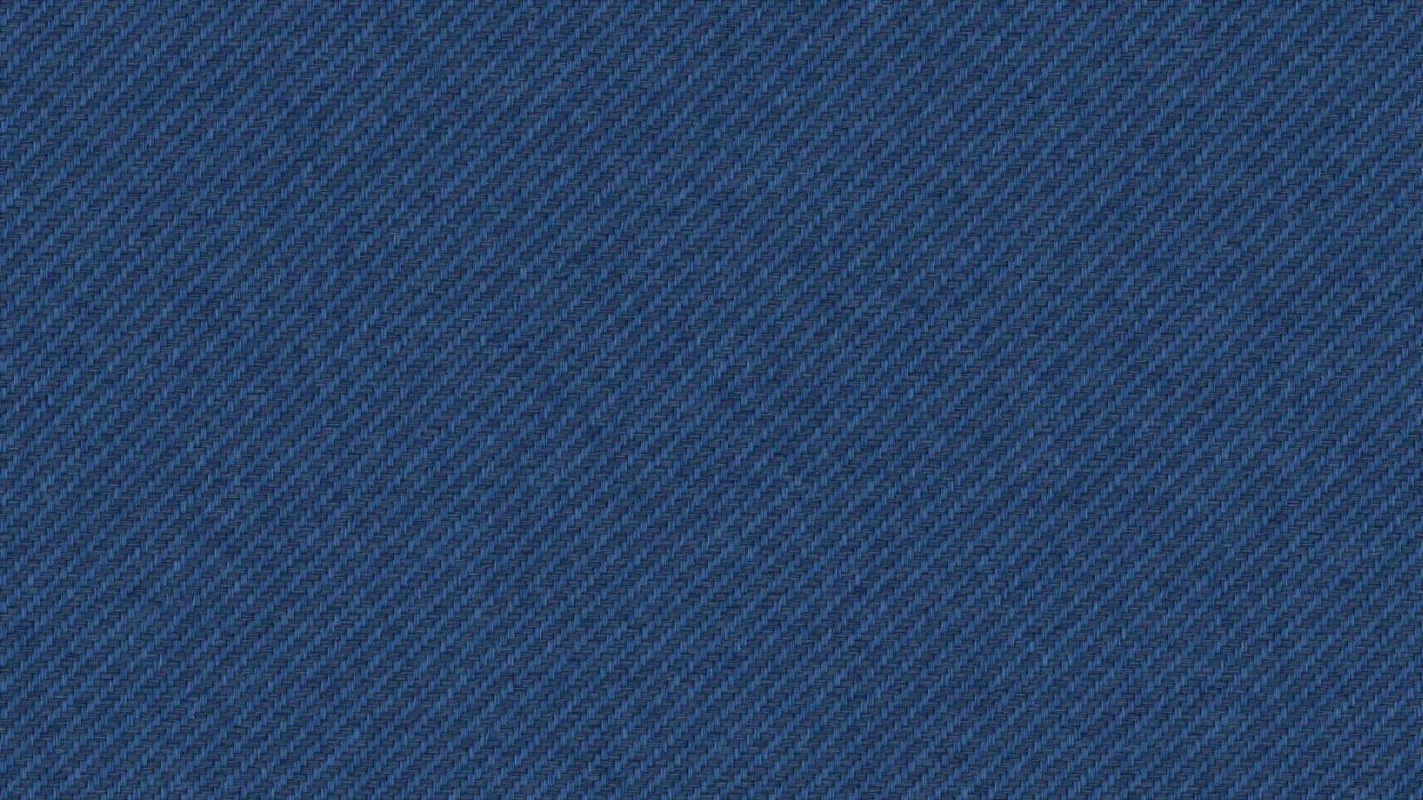 Jeans 桌布 壁紙 — 豐富靛藍牛仔布料的特寫，帶有斜紋編織質地和微妙的褪色效果。