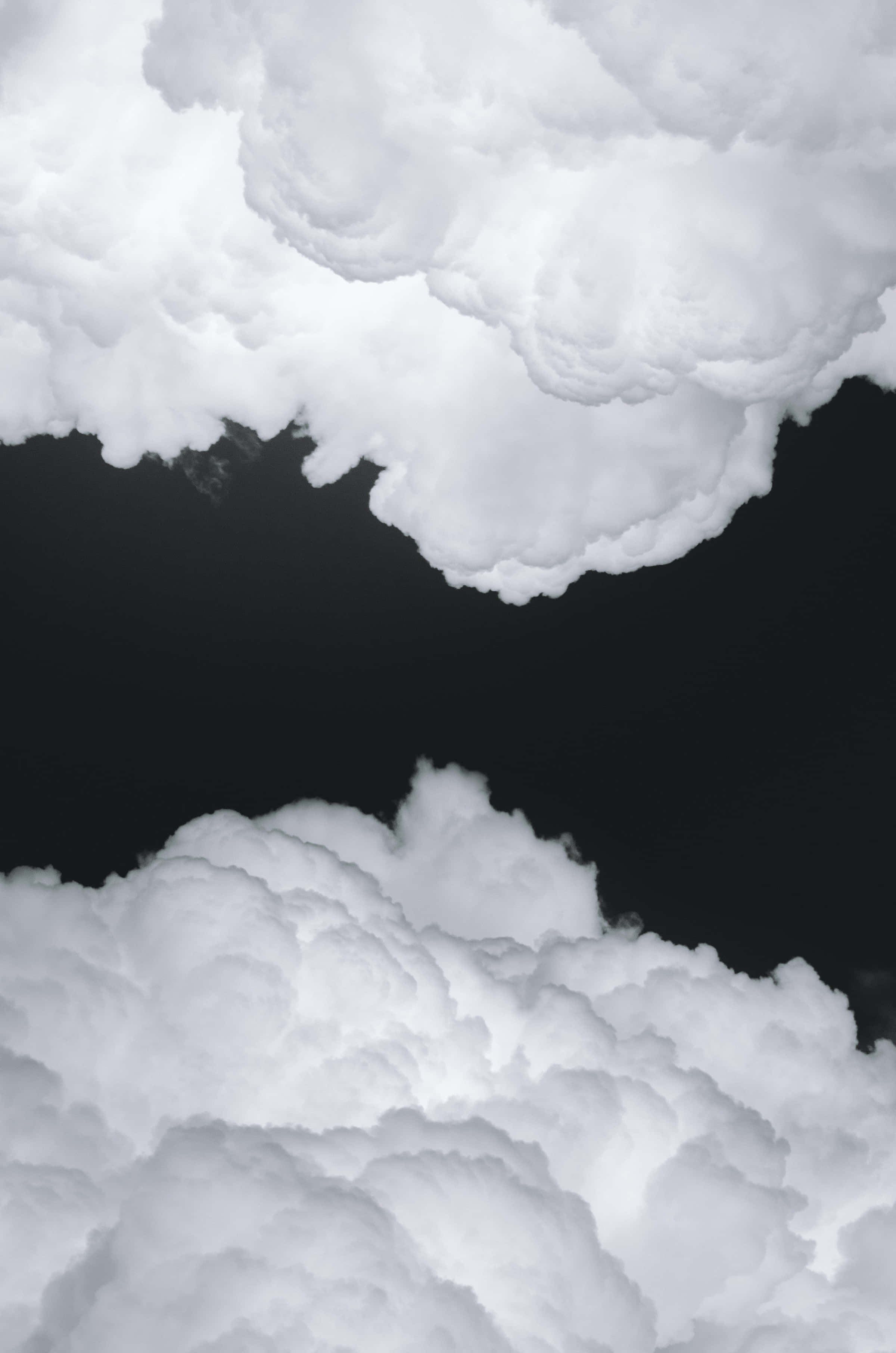 Black And White Sky 桌布 壁紙 — 豐盈的白雲在漆黑的天空中飄浮，營造出高對比度的戲劇性場景。