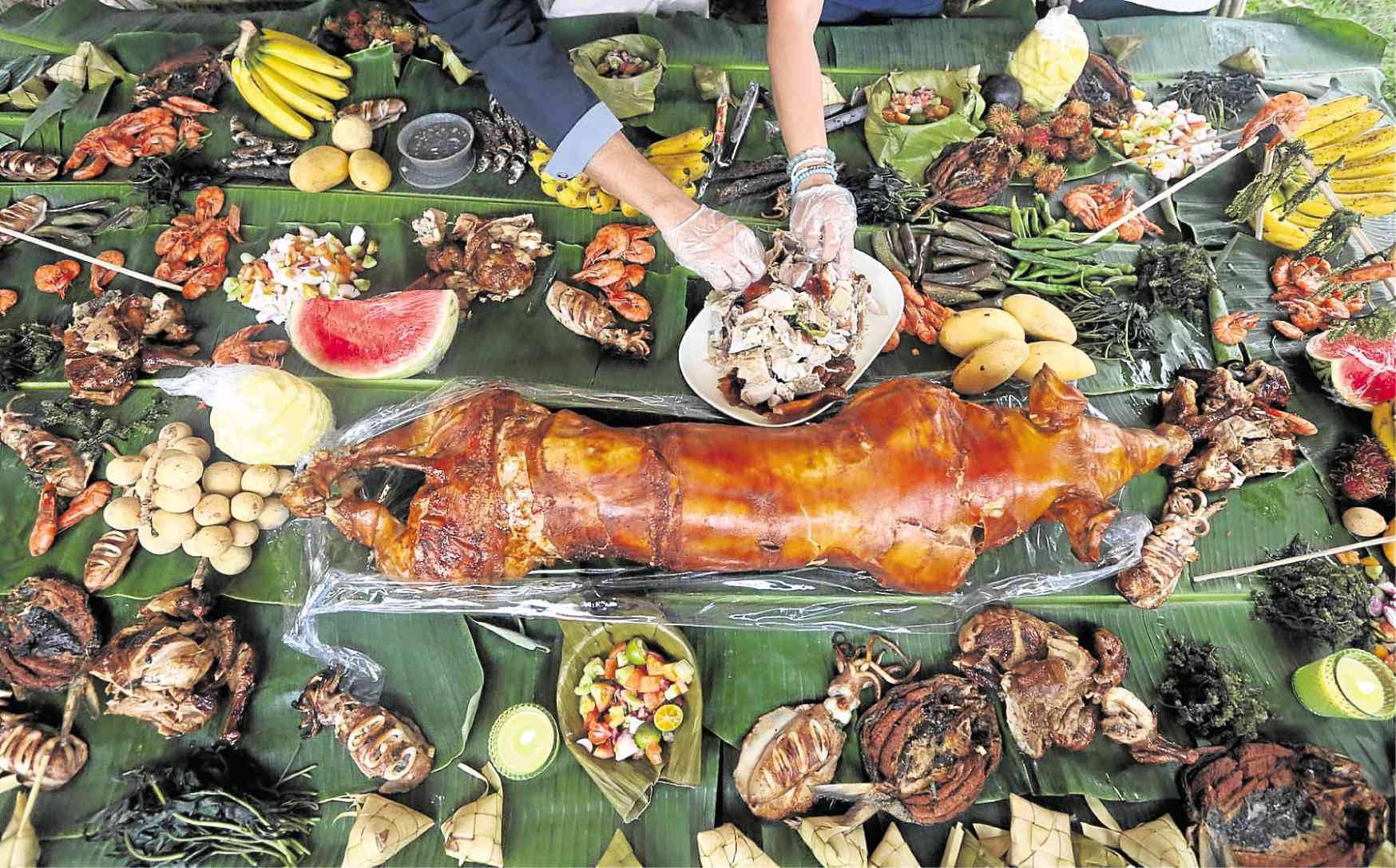 Pig 桌布 壁紙 — 豐盛的烤豬和熱帶菜餚擺放在香蕉葉上，適合節日盛宴。