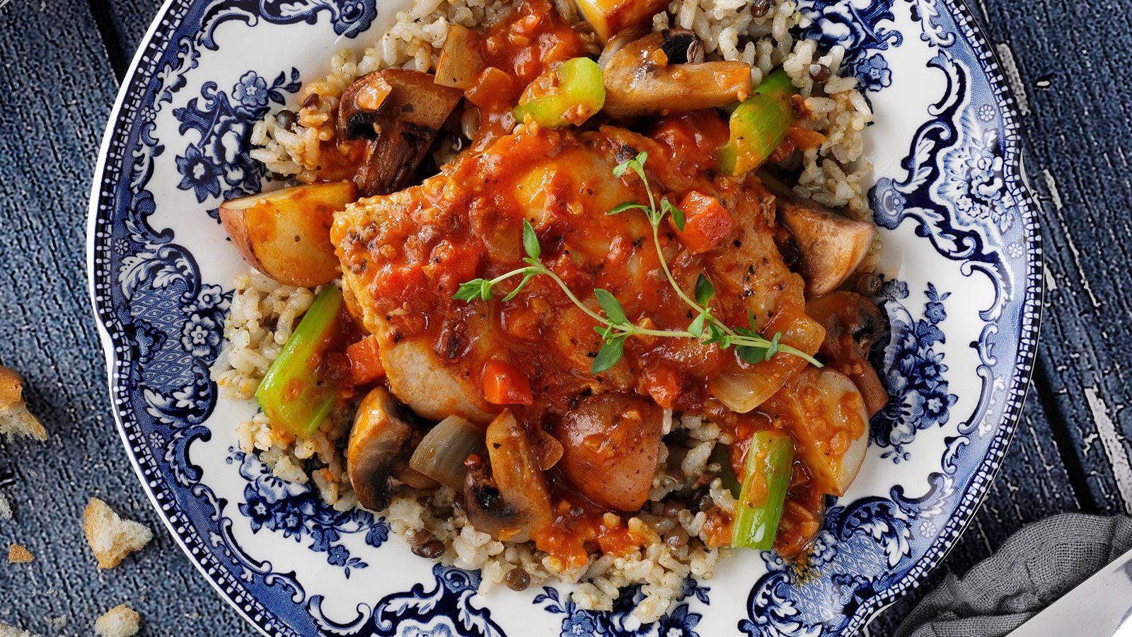 Food Photography 桌布 壁紙 — 豐盛的魚湯配蘑菇和青椒，放在糙米上，盛在華麗的藍白盤中。