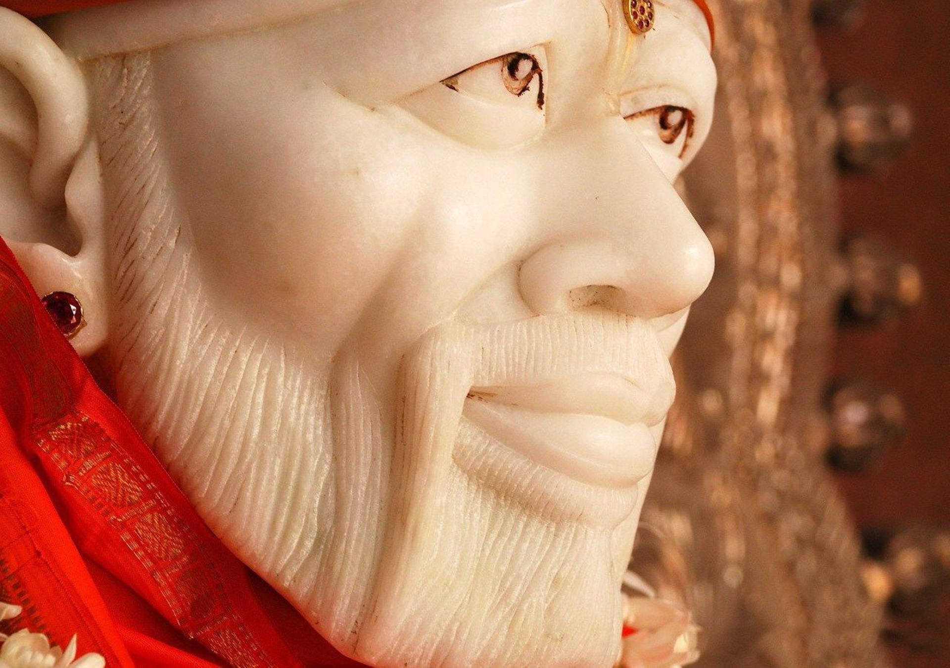 象牙雕刻神像特寫，肩上披著紅布。 — 4K 壁紙
