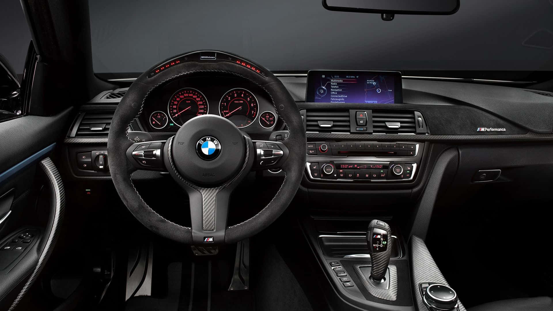 BMW 動圖 桌布 壁紙 — 豪華BMW M汽車內裝，帶有黑色碳纖維飾邊、紅色發光儀表板和運動型方向盤。