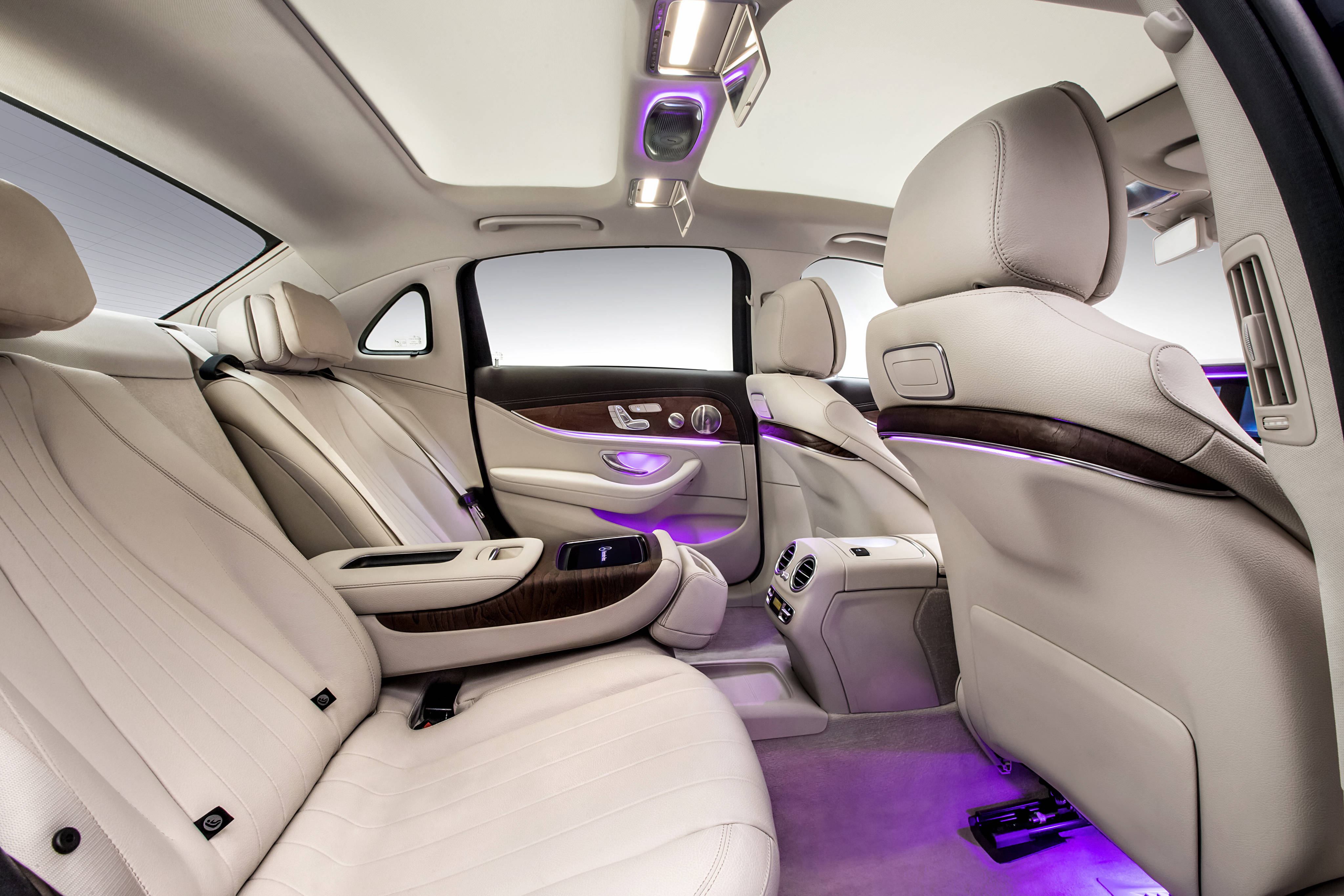 Mercedes 桌布 壁紙 — 豪華奶油色皮革車廂內飾，配以環境紫色燈光和木質飾條。