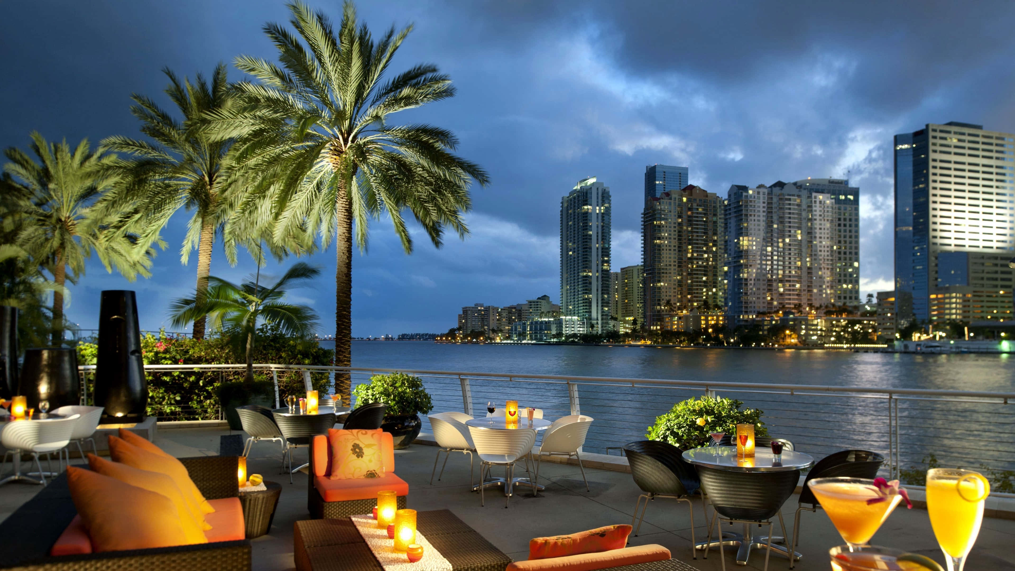 Miami 4K 桌布 壁紙 — 豪華屋頂酒廊，棕櫚樹和閃爍的雞尾酒，俯瞰暮色中閃閃發光的城市天際線。