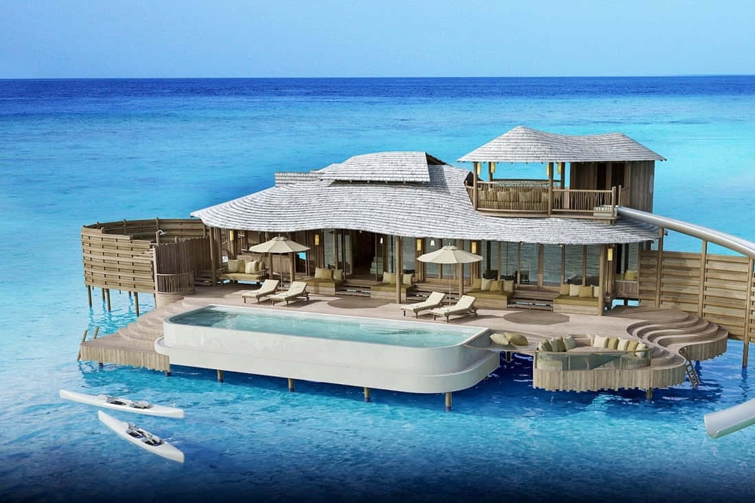 Maldives Island 桌布 壁紙 — 豪華水上別墅，設有私人泳池和滑梯，漂浮在碧綠海洋上，天空湛藍清澈。
